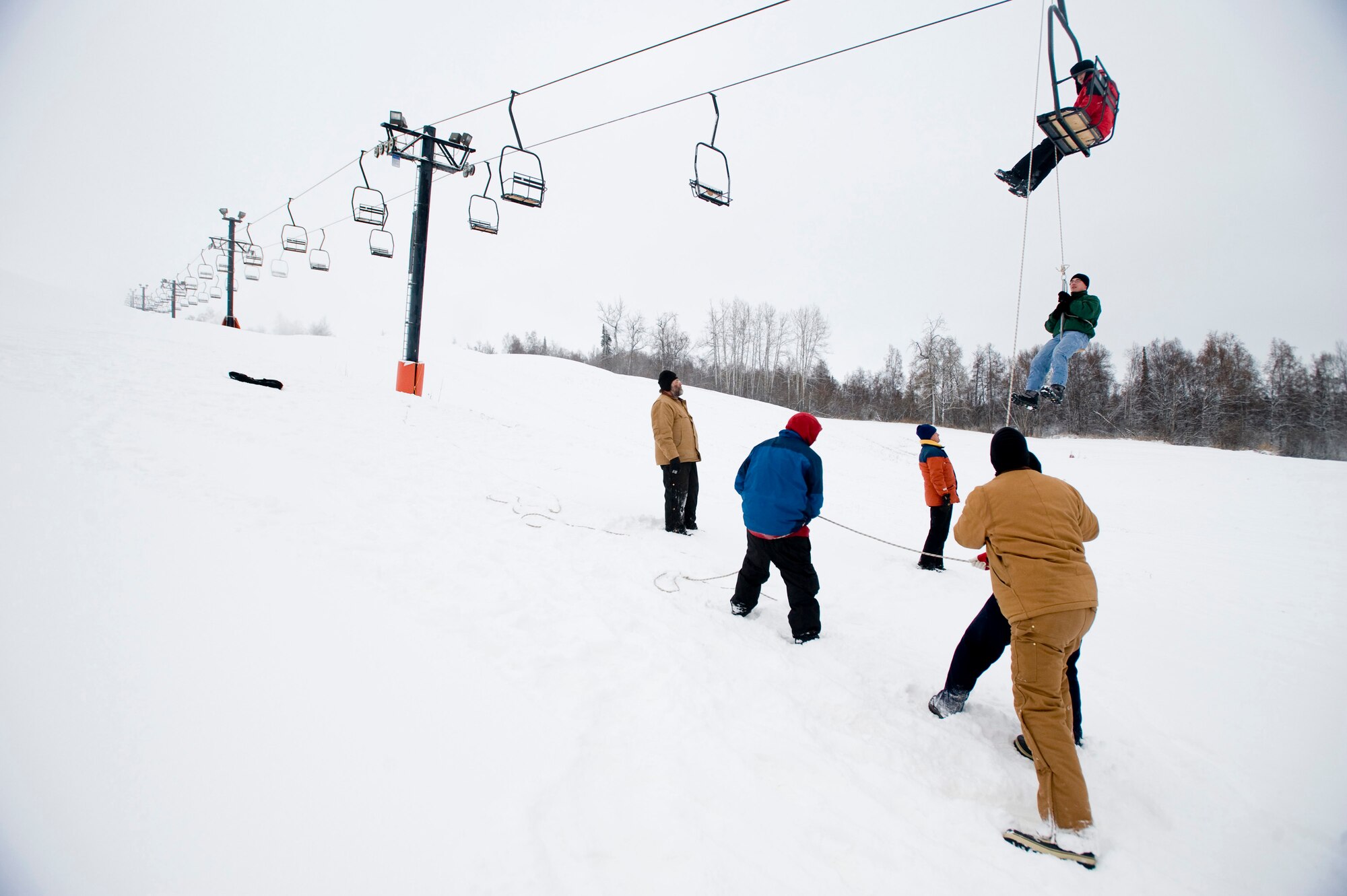 ELMENDORF AIR FORCE BASE, Alaska -- Airman 1st Class Gregory Mackel, 3rd Communications Squadron, is lowered from the ski lift Nov. 23. The ski patrols performed training on ski-lift evacuation prior to Hillberg's opening this week. (U.S. Air Force photo/Senior Airman Jonathan Steffen)