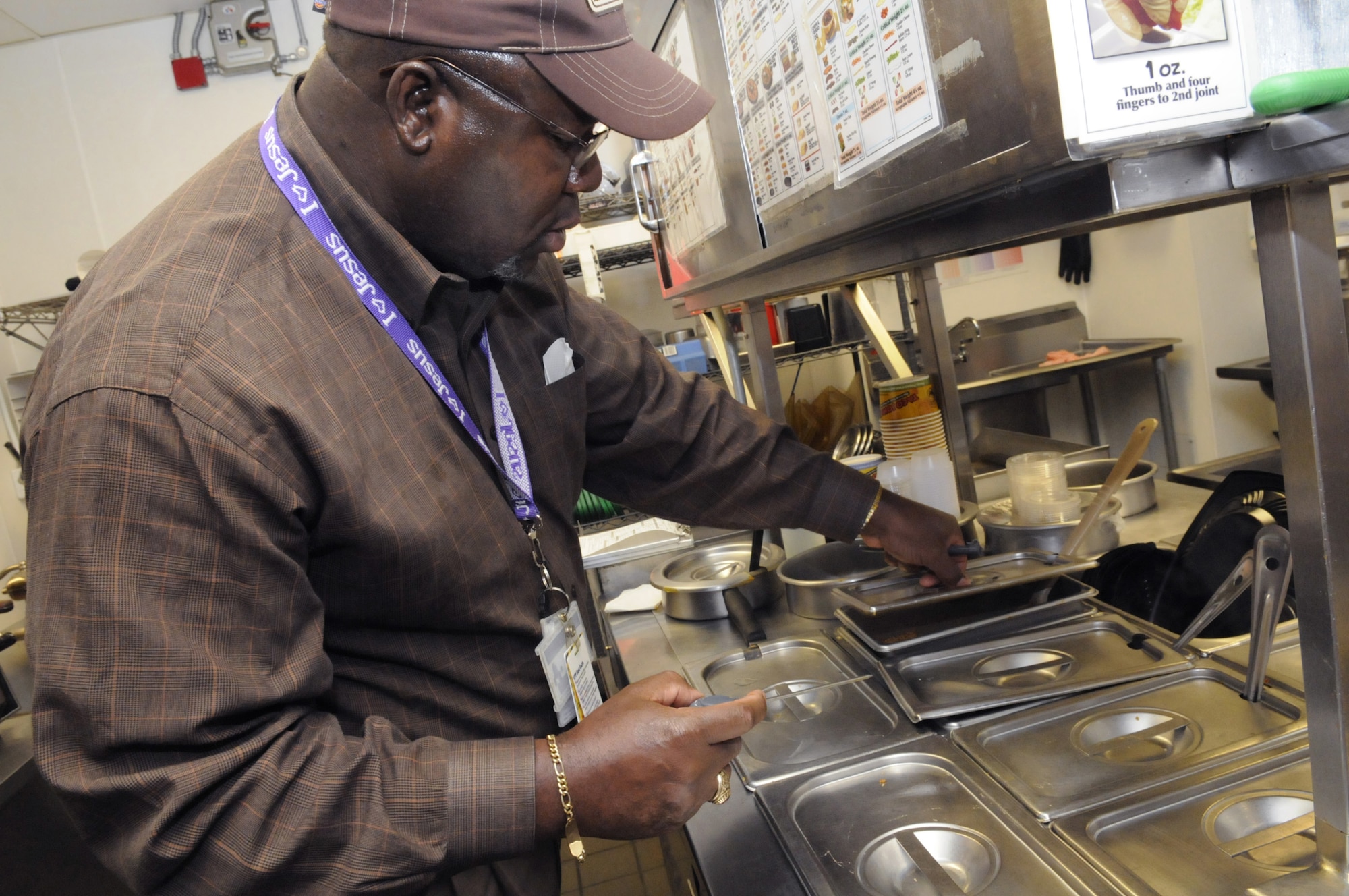 Fred Brown checks the temperature on hot items to make sure they are 135 degrees or higher in the kitchen of Taco Johns in the BX food court Oct. 9. U. S. Air Force photo by Sue Sapp