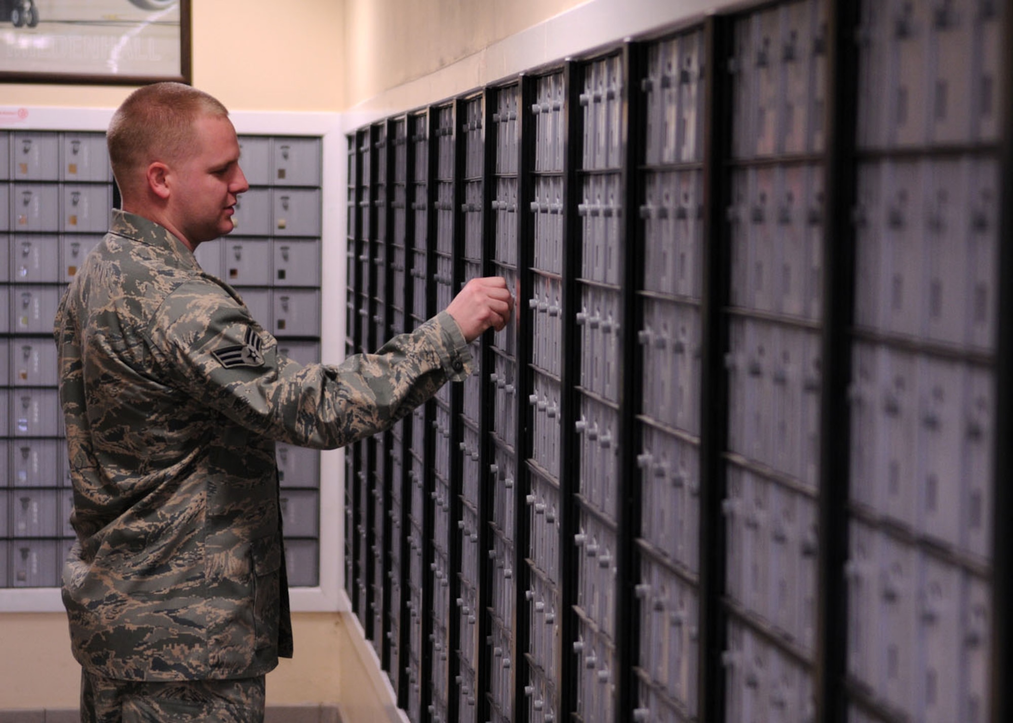 Senior Airman Erik Eller, a military postal clerk from the 100th Communications Squadron, checks his mailbox at the post office Nov. 20, 2008, at RAF Mildenhall, England. Military members assigned mail boxes are asked to check them at least three times a week to avoid overflowing their boxes with mail. (U.S. Air Force photo by Staff Sgt. Jerry Fleshman)