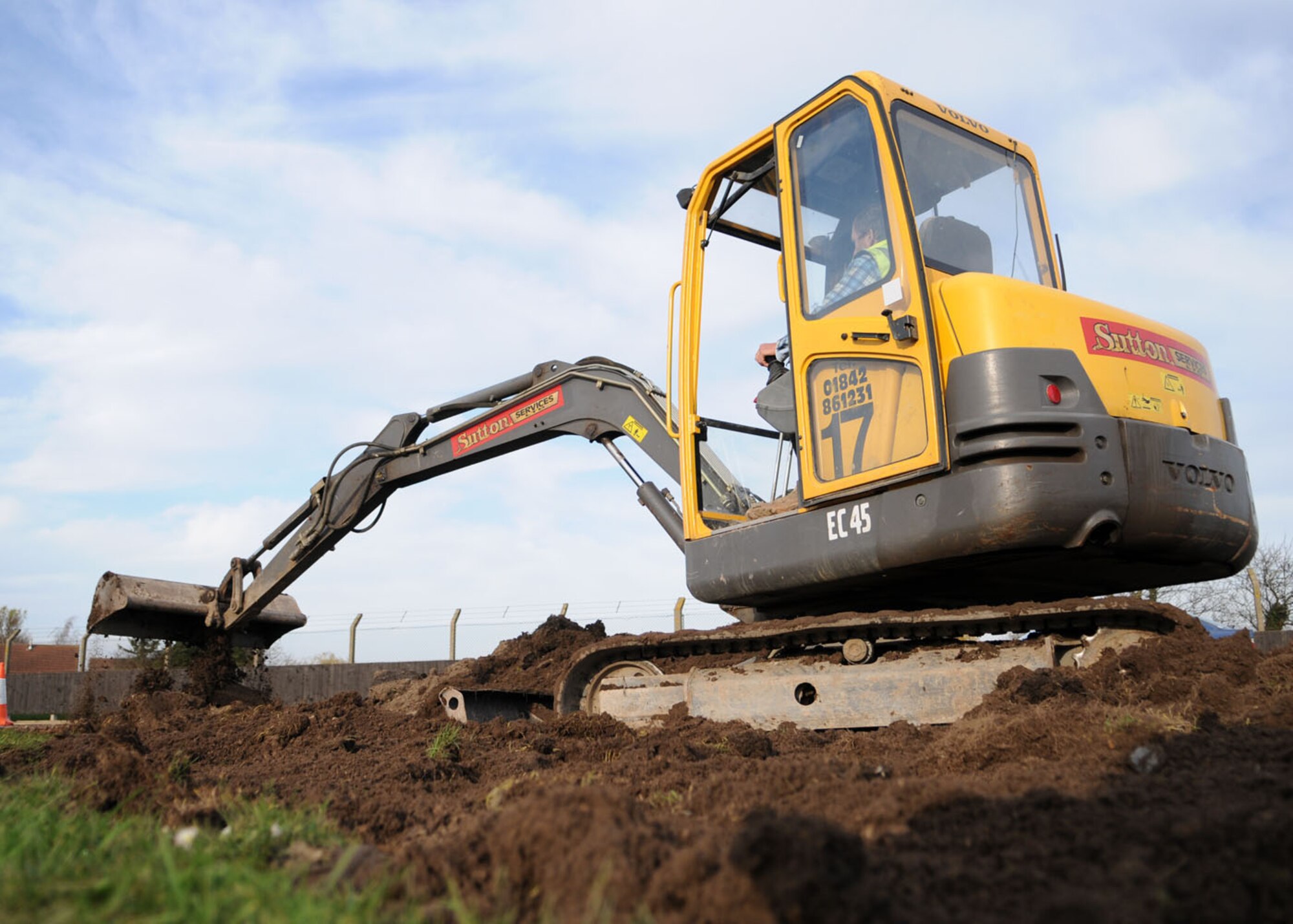 Robert Saunders, a contracted heavy equipment operator, maneuvers a mini excavator to even out mounds of dirt created by the removal of an access road during a reconstruction project on Perimeter Road Nov. 19, 2008 at RAF Mildenhall, England. The project will provide more room for equipment and provide a running path so runners no longer need to run near the road. (U.S. Air Force photo by Staff Sgt. Jerry Fleshman)
