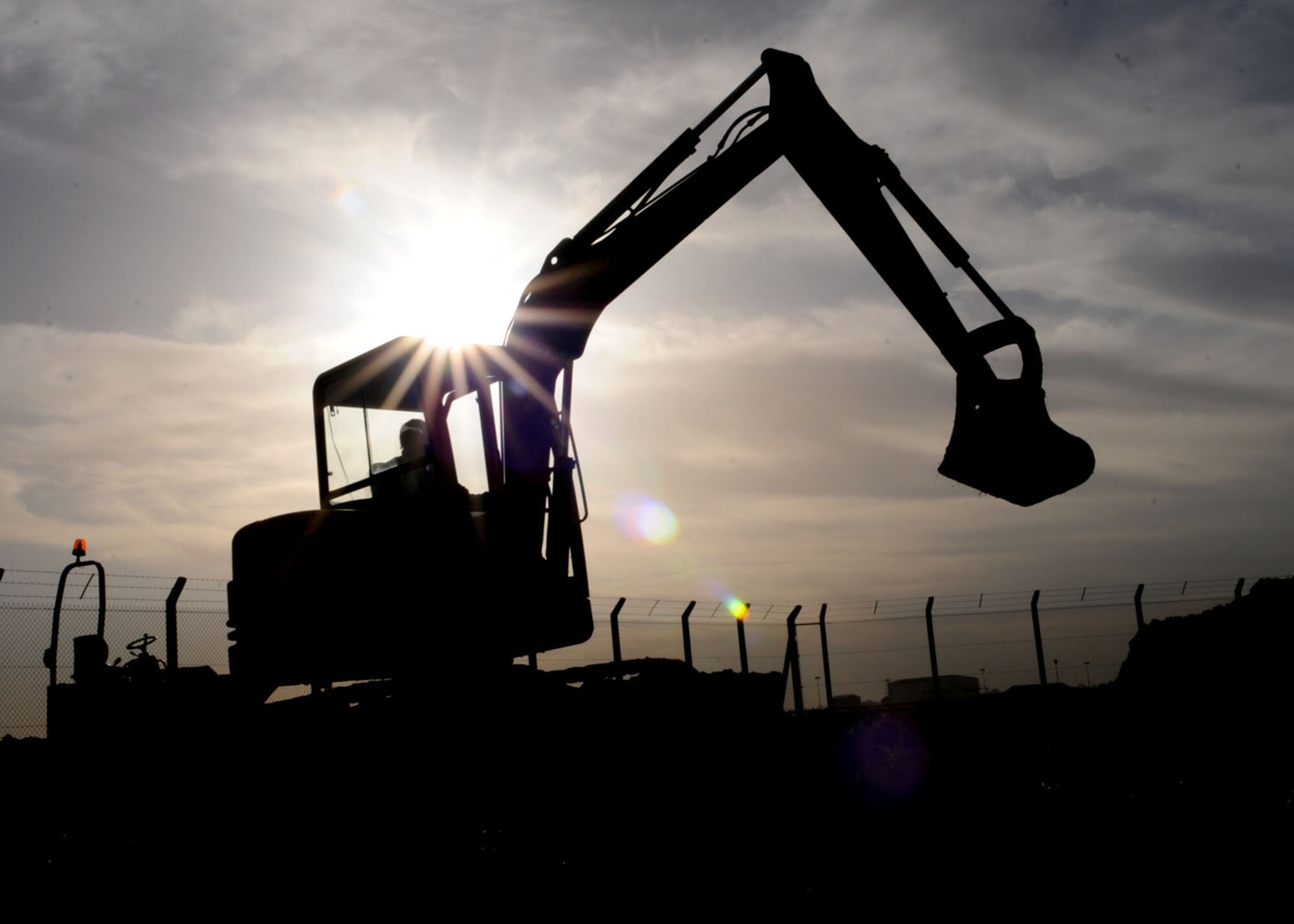 Robert Saunders, a contracted heavy equipment operator, maneuvers a mini excavator to even out mounds of dirt created by the removal of an access road during a reconstruction project on Perimeter Road Nov. 19, 2008 at RAF Mildenhall, England. The project will provide more room for equipment and provide a running path so runners no longer need to run near the road. (U.S. Air Force photo by Staff Sgt. Jerry Fleshman)
