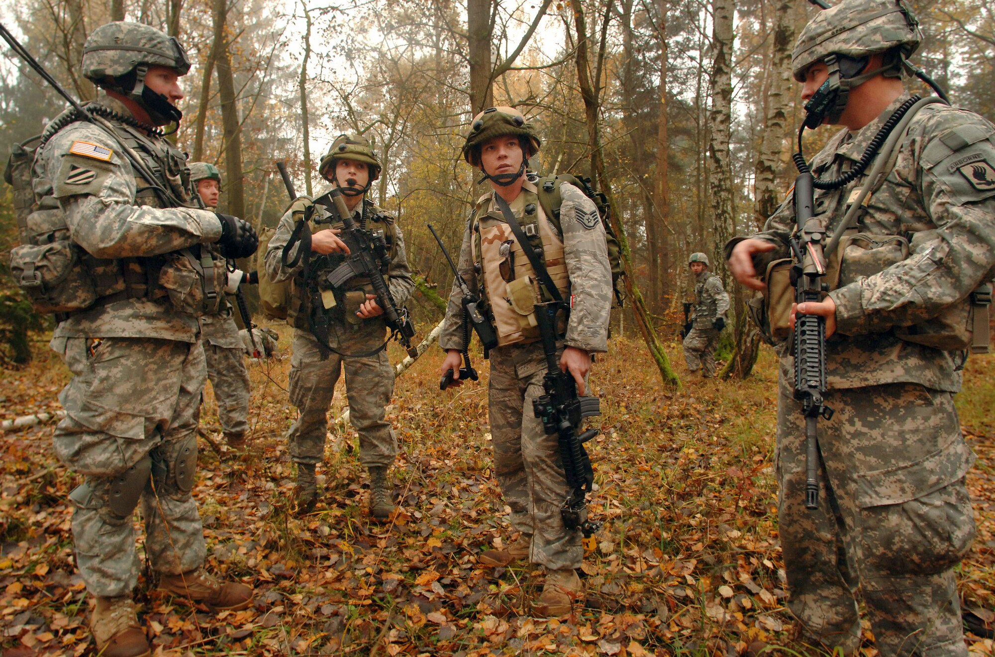 Staff Sgt. William Thomas (center) and Airman 1st Class Michael Kelley accompany U.S. Army Soldiers in hiking to a nearby village for an urban warfare scenario during Exercise Allied Strike II Nov. 4 at Hohenfels Army Garrison, Germany. The Airmen assisted the 173rd Air Brigade Combat Team, 191 Cavalry, in pursuit of a "high-valued target" by facilitating close-air-support when needed. The week-long joint terminal air controller-centric exercise involves 90 U.S. and coalition personnel with close air support assets from five U.S. and coalition air wings and is designed to prepare U.S. Air Forces Europe and NATO JTACs for Operation Iraqi Freedom and Operation Enduring Freedom. The Airmen are assigned to 1st Air Support Operations Squadron in Wiesbaden, Germany. Sergeant Thomas is a JTAC and Airman Kelley is a radio operator maintainer and driver. (Defense Department photo/Master Sgt. Scott Wagers)