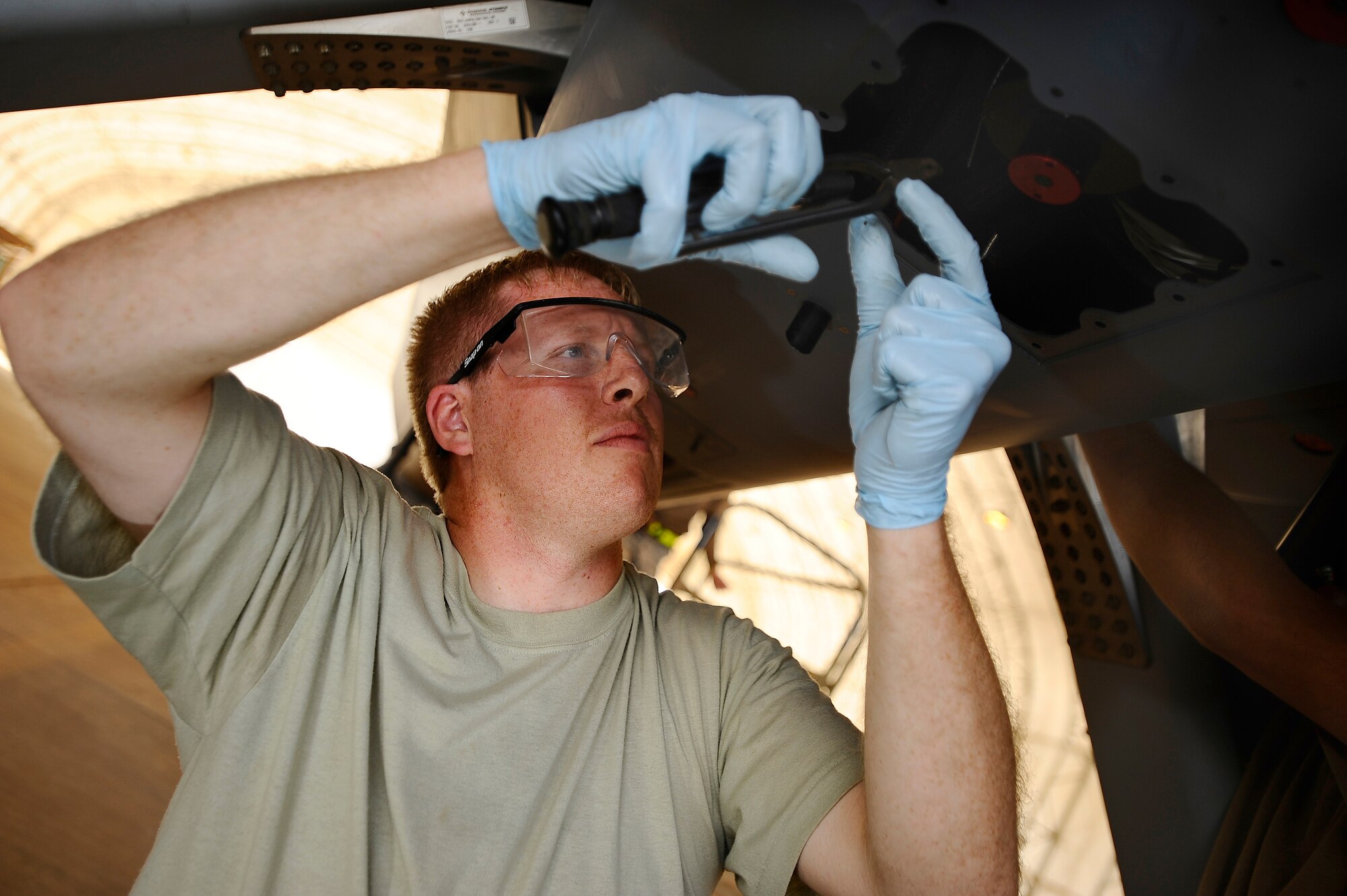 Senior Airman Timothy Boden attaches safety wiring to the underside of an MQ-9 Reaper at Joint Base Balad, Iraq, Nov. 22. A coalition force of experts from the U.S. Air Force and Royal Air Force deployed here to man a new Reaper aircraft maintenance unit. The unit is attached to the 46th Expeditionary Reconnaissance and Attack Squadron and assumed maintenance duties from General Atomics, which produces the Reaper for these services. Boden, a Reaper crew chief assigned to the 332nd Expeditionary Aircraft Maintenance Squadron, is deployed from Creech Air Force Base, Nev. His hometown is Bismarck, Ill. (U.S. Air Force photo/Airman 1st Class Jason Epley)(Released)