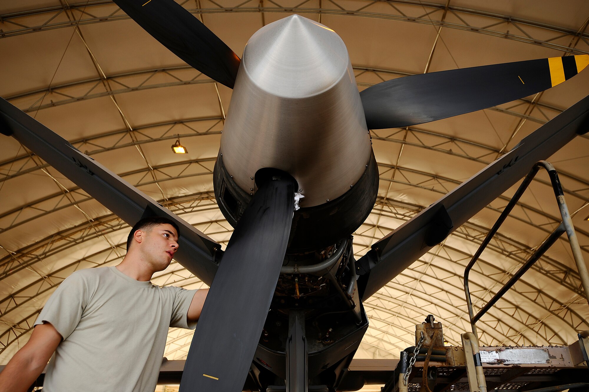 Senior Airman Hector Sanchez wipes carbon build up off the propeller of an MQ-9 Reaper at Joint Base Balad, Iraq, Nov. 22. Carbon builds on the propeller from the Reaper's exhaust. A coalition force of experts from the U.S. Air Force and Royal Air Force deployed here to man a new Reaper aircraft maintenance unit. The unit is attached to the 46th Expeditionary Reconnaissance and Attack Squadron and assumed maintenance duties from General Atomics, which produces the Reaper for these services. Sanchez, a Reaper crew chief assigned to the 332nd Expeditionary Aircraft Maintenance Squadron, is deployed from Creech Air Force Base, Nev. His hometown is Utuado, Puerto Rico. (U.S. Air Force photo/Airman 1st Class Jason Epley)(Released)