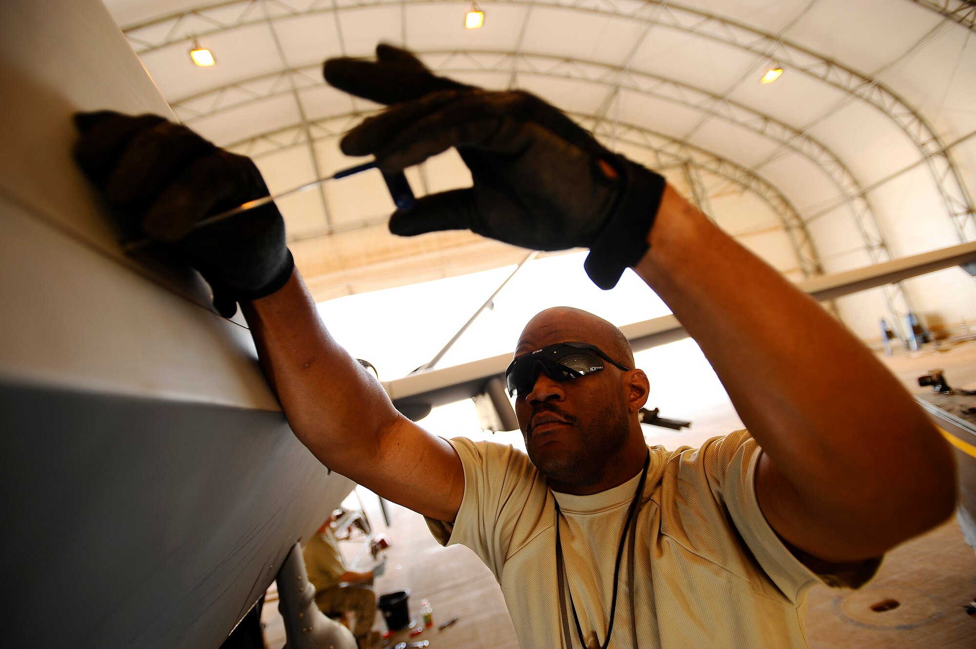 Tech. Sgt. Fred Spears secures the satellite communication radome to an MQ-9 Reaper at Joint Base Balad, Iraq, Nov. 22. A coalition force comprising experts from the U.S. Air Force and Royal Air Force deployed here to man a new Reaper aircraft maintenance unit, attached to the 46th Expeditionary Reconnaissance and Attack Squadron, and assume maintenance from General Atomics, which produces the Reaper for these services. Spears, a Reaper avionics specialist assigned to the 332nd Expeditionary Aircraft Maintenance Squadron, is deployed from Creech Air Force Base, Nev. His hometown is Longview, Texas. (U.S. Air Force photo/Airman 1st Class Jason Epley)(Released)