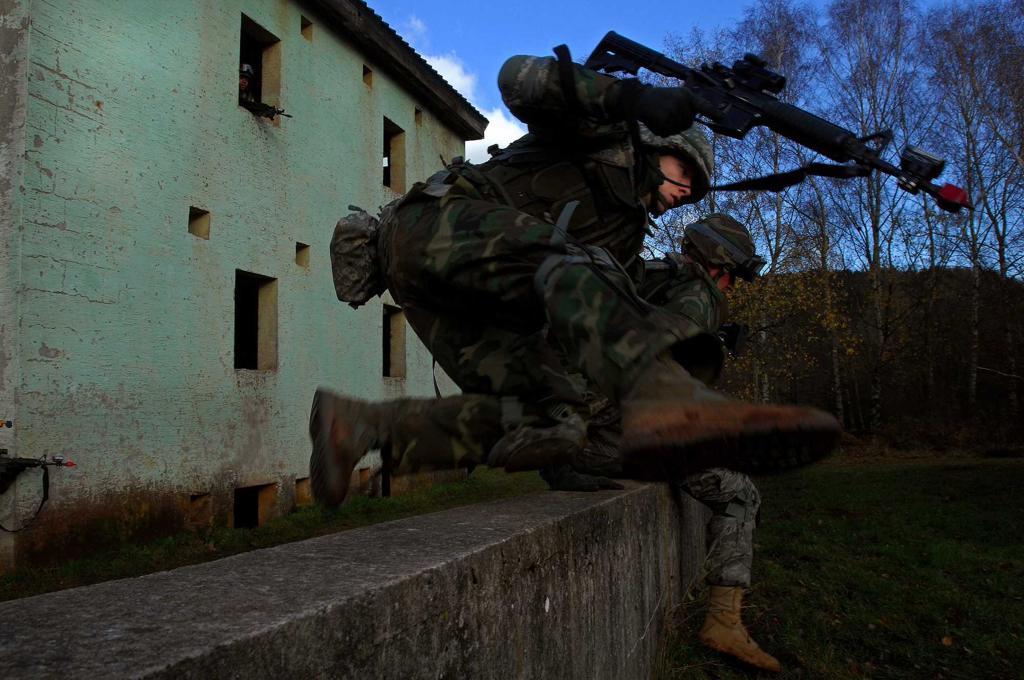 Airman 1st Class Chris Cunningham, 423rd Security Forces Squadron, Royal Air Force Alconbury, England, jumps over a wall to fall in line with his fire team during urban operations training as a part of a two-week long Creek Defender course, Nov. 17, 2008, Baumholder Germany. (U.S. Air Force photo by Airman 1st Class Kenny Holston)