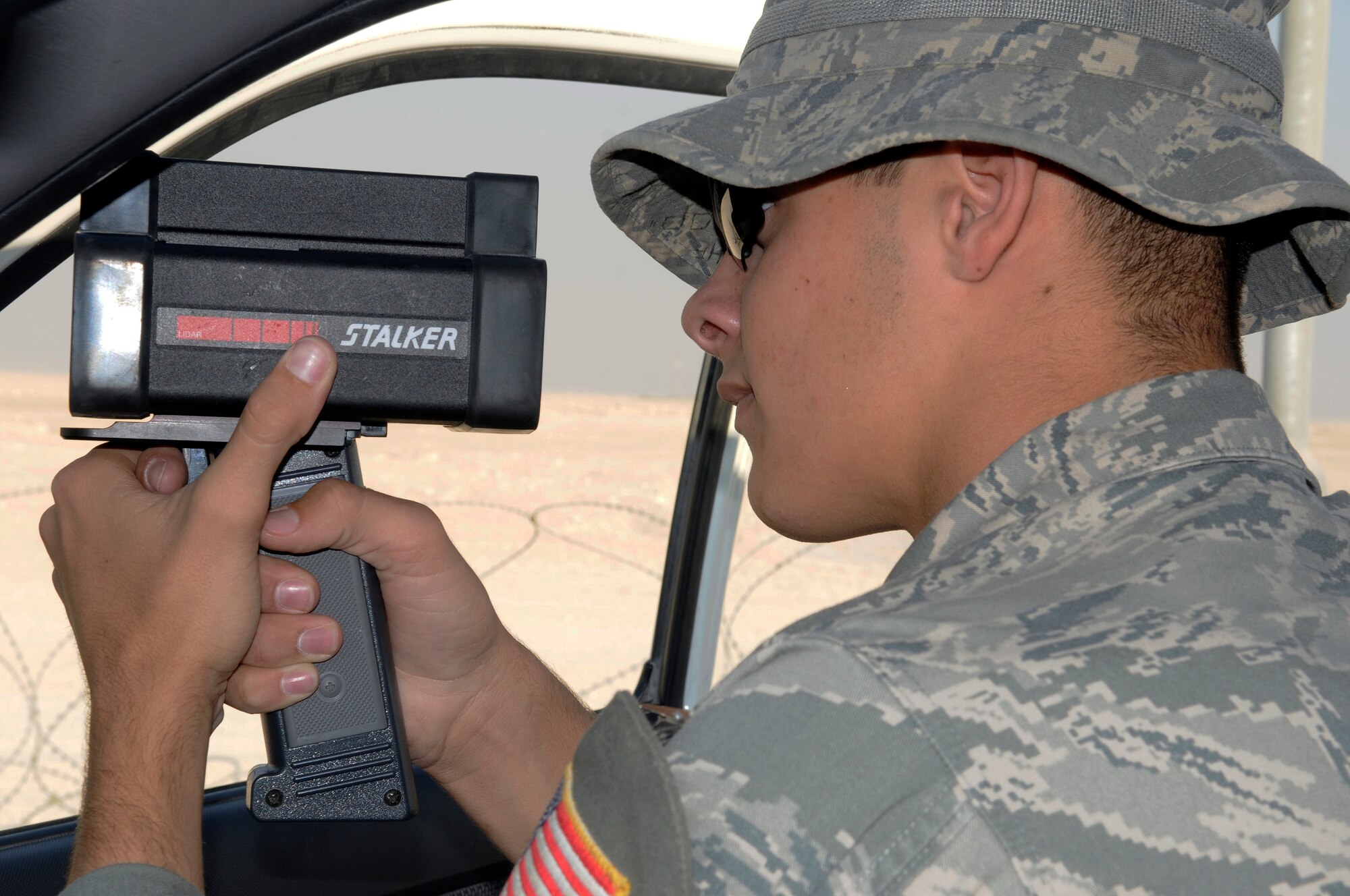 Airman 1st Class Mathew Meadows, 379th Expeditionary Security Forces Squadron, uses a radar gun to check for speeding vehicles, Nov. 22, at an undisclosed air base in Southwest Asia.  Security Forces patrolmen maintain speed limits on base to ensure the safety of all personnel, vehicle operators as well as pedestrians.  Airman Meadows, a native of Elk Point, S.D., is deployed from Tyndall Air Force Base, Fla., in support of Operations Iraqi and Enduring Freedom and Joint Task Force-Horn of Africa.  (U.S. Air Force photo by Tech. Sgt. Michael Boquette/Released)