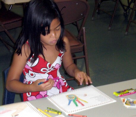 Rynelle Acasio, daughter of Ruby and Master Sgt. Danny Acasio, 36th Medical Group, makes a project at the Hearts Apart dinner Nov. 6. The project will be sent to her father, who is currently on a remote tour in Kunsan Air Base, South Korea. (Courtesy photo)
