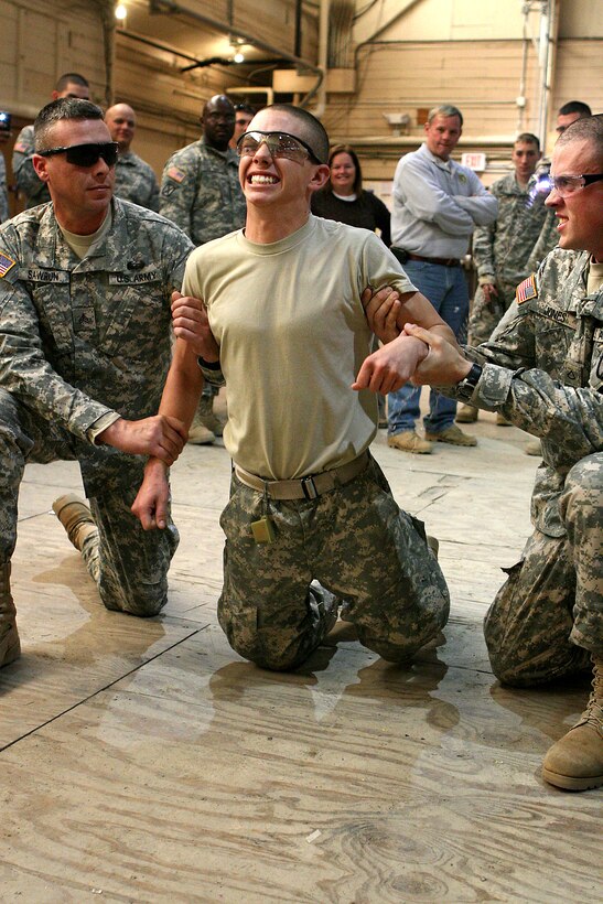 U.S. Army Pfc. Justin Griffin, center, a combat engineer assigned to the 10th Mountain Division's Company A, 3rd Special Troops Battalion, 3rd Brigade Combat Team, learns what a Taser gun feels like during non-lethal weapons training on Fort Drum, N.Y., Nov. 19, 2008.