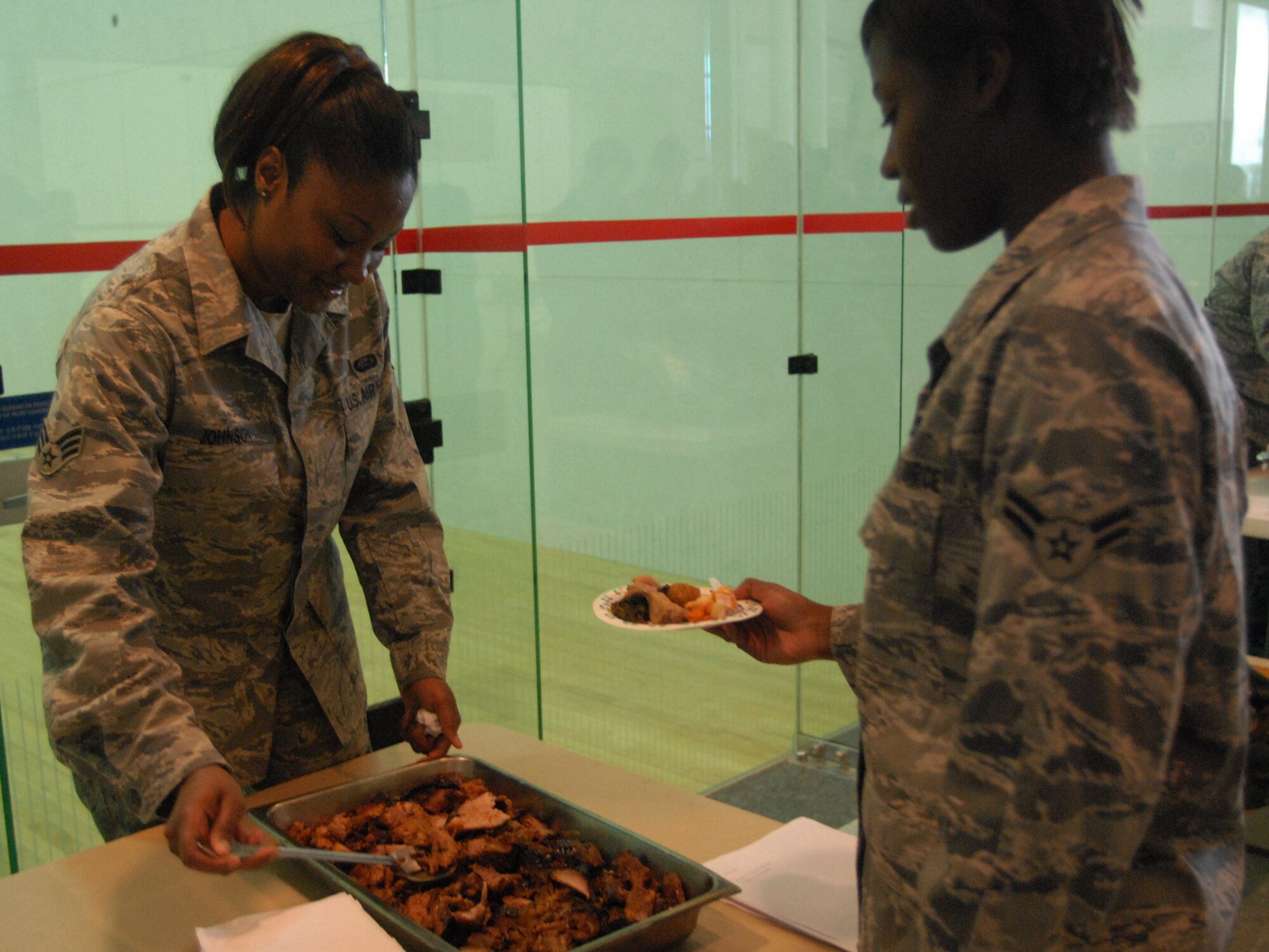 Senior Airman Amanda Johnson, 8th Force Support Squadron, serves up barbecue pork during Diversity Day at Kunsan Air Base, Republic of Korea, Nov. 25, 2008. Diversity Day celebrates the many different cultures working together around the Air Force. (U.S. Air Force Photo/Senior Airman Gustavo Gonzalez) 
