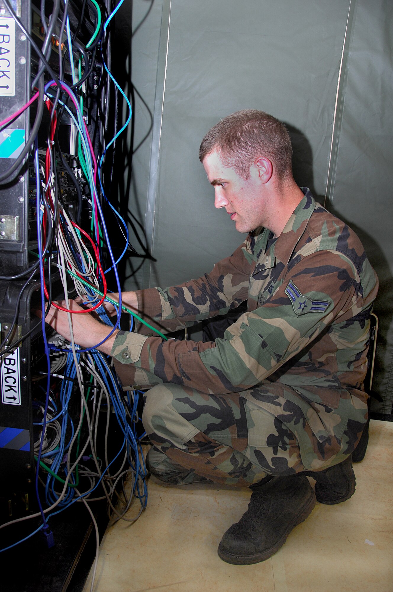 ANDERSEN AIR FORCE BASE, Guam - Airman 1st Class Joseph Lapthorne, 644th Combat Communications Squadron network control center operator, ensures local area connection cables are secure during the squadron's Dragon Thunder field training exercise Nov. 20 here. The field training exercise sharpened the 644th CBCS Airmen's expeditionary skills.