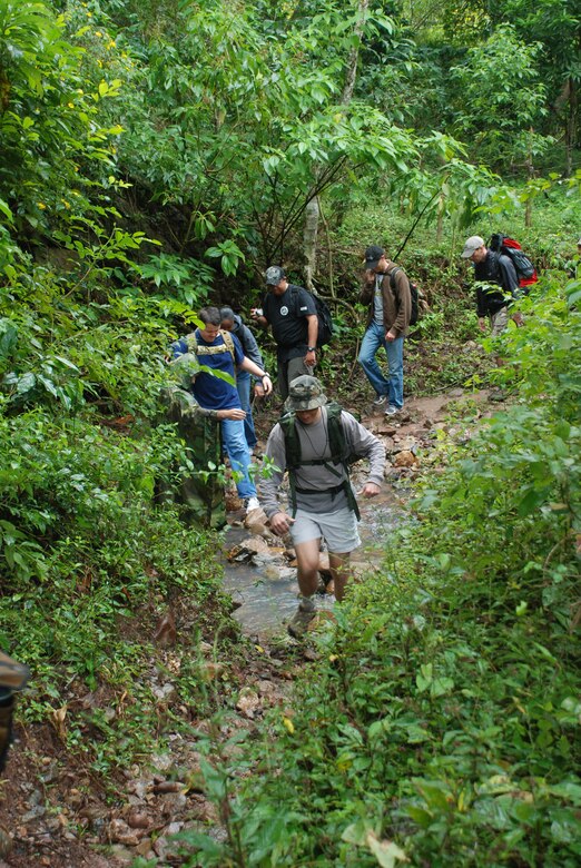 Military members from Joint Task Force-Bravo and the Honduran Air Force Academy crossed a stream on the chapel hike to bring food to the village of El Negrito. More than 110 people hiked about four miles to bring food to the people of the village. (U.S. Air Force photo by Tech. Sgt. John Asselin).