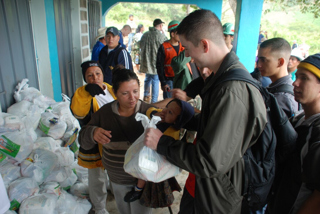 Air Force 2nd Lt. Timothy Underwood helps distribute food to residents of El Negrito as part of Joint Task Force-Bravo's monthly chapel hike program. Nearly 115 U.S. and Honduran military members volunteered to hike more than four miles through the mountain-side jungle to bring food to the residents of the village. (U.S. Air Force photo by Tech. Sgt. John Asselin)