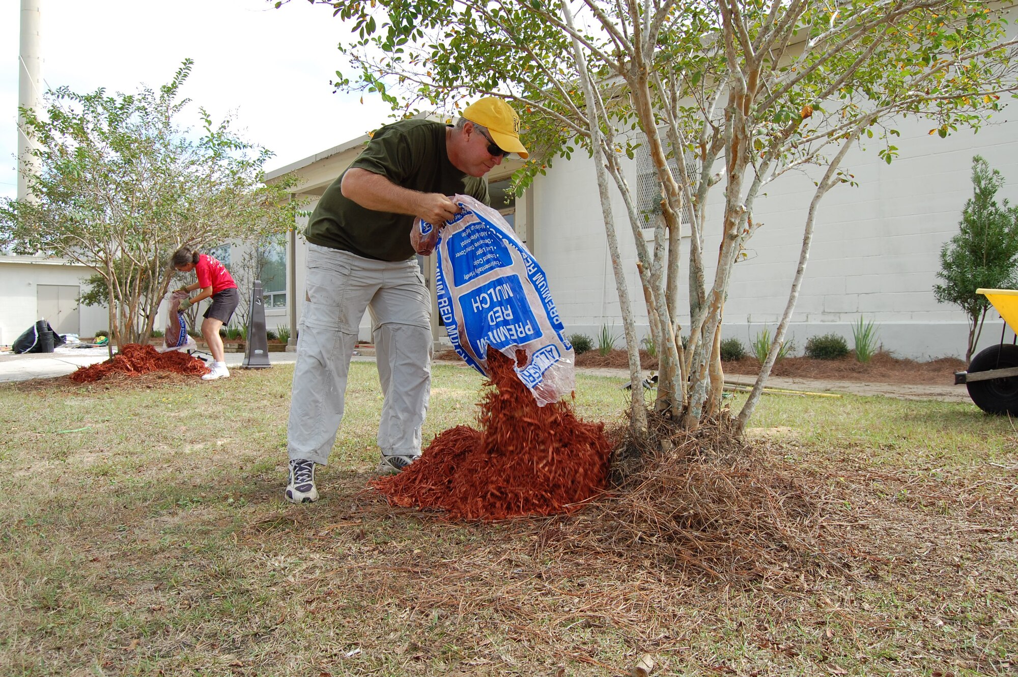 Master Sgt. Tom Haddock (foreground), Top 3 president, and Senior Master Sgt. Laurie Klausutis, install new cypress mulch outside Duke Field's Outpost facility during the organization's recent landscaping project.  A dozen Top 3 members volunteered their time to spruce up the base's appearance there and at the gate along Highway 85.  (Courtesy photo).