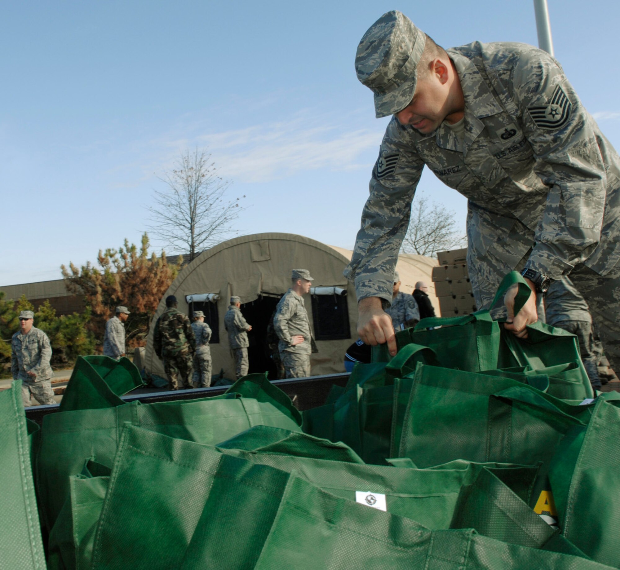 LANGLEY AIR FORCE BASE, Va.-- Tech. Sgt. Michael Alvarez, 27th Intelligence Support Squadron, loads bags filled with collected food items during Operation Warm Heart Nov. 25.  These bags were distributed to more than 400 families in need of a Thanksgiving meal.  Warm Heart volunteers also raised more than $20,000 to support Airmen in need year round. (U.S. Air Force/Staff Sgt. Tabitha Kuykendall)