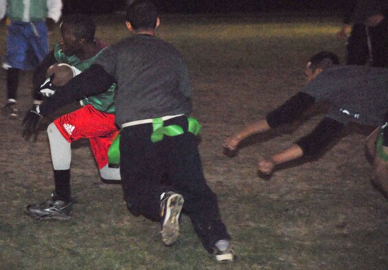 James McNeil, 436th Services Squadron wide receiver, runs past two 436th Mission Support Squadron defensive players in their game Nov. 12.  SVS defeated MSS 7 - 6.