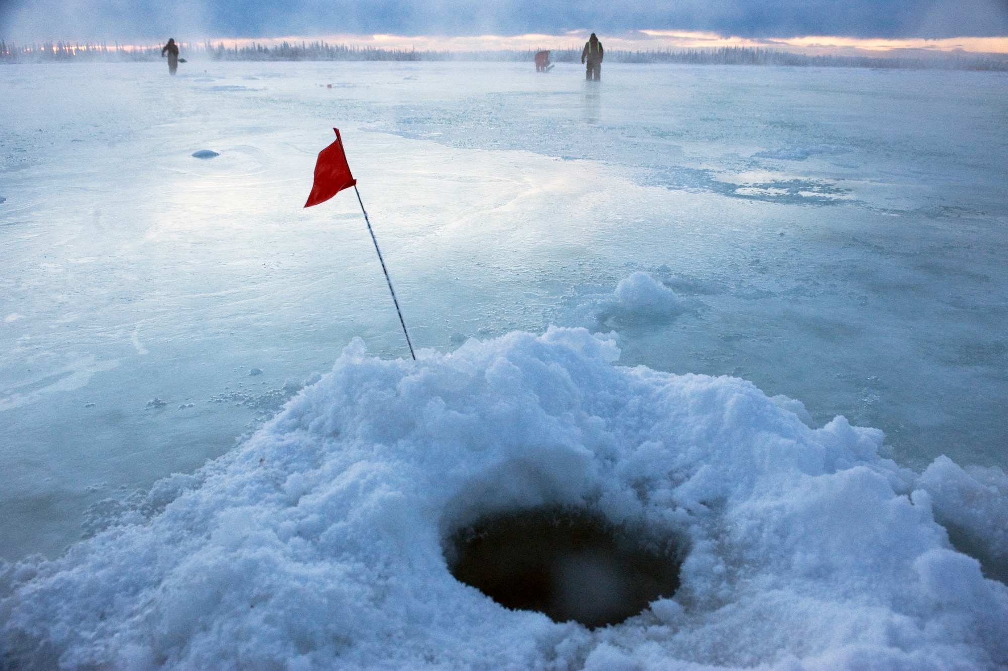 Airmen of 354th Civil Engineer Squadron range maintenance mark the holes they drill into the ice to make it easier to find when they return with water pumps Nov. 24, 2008, in Fairbanks, Alaska. The ice bridge takes six to 10 weeks to complete in sub-zero weather. It is five-feet deep, 32 miles long and capable of supporting more than 110 tons -- and will melt back into the river when spring thaw hits. The ice bridge enables 354th CES Airmen to access and perform annual maintenance at Blair Lakes Bombing Range.  (U.S. Air Force photo/Senior Airman Jonathan Snyder)