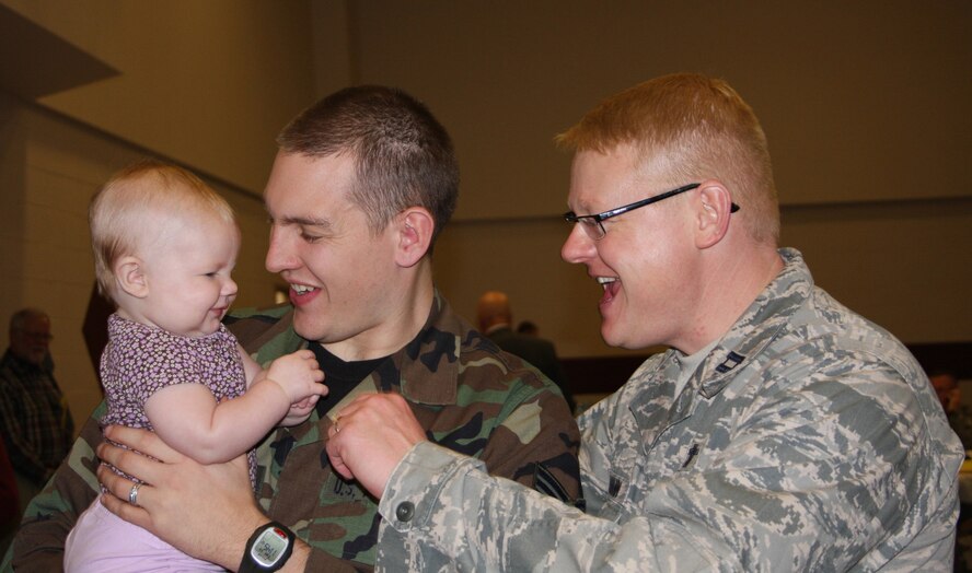 WRIGHT-PATTERSON AFB, Ohio - Staff Sgt. Benjamin Bratka, 445th Airlift Wing shows off baby Emma to Chaplain (Capt.) Jonathan Kollmann during the 445th Yellow Ribbon Pre-Deployment Town Hall meeting Nov. 18, 2008. More than 90 445th Airlift Wing reservists and family members attended the Yellow Ribbon Pre-Deployment Town Hall meeting. The town hall marked the first pre-deployment Yellow Ribbon Town Hall hosted by an Air Force Reserve Command unit.(Air Force photo/Laura Darden)  