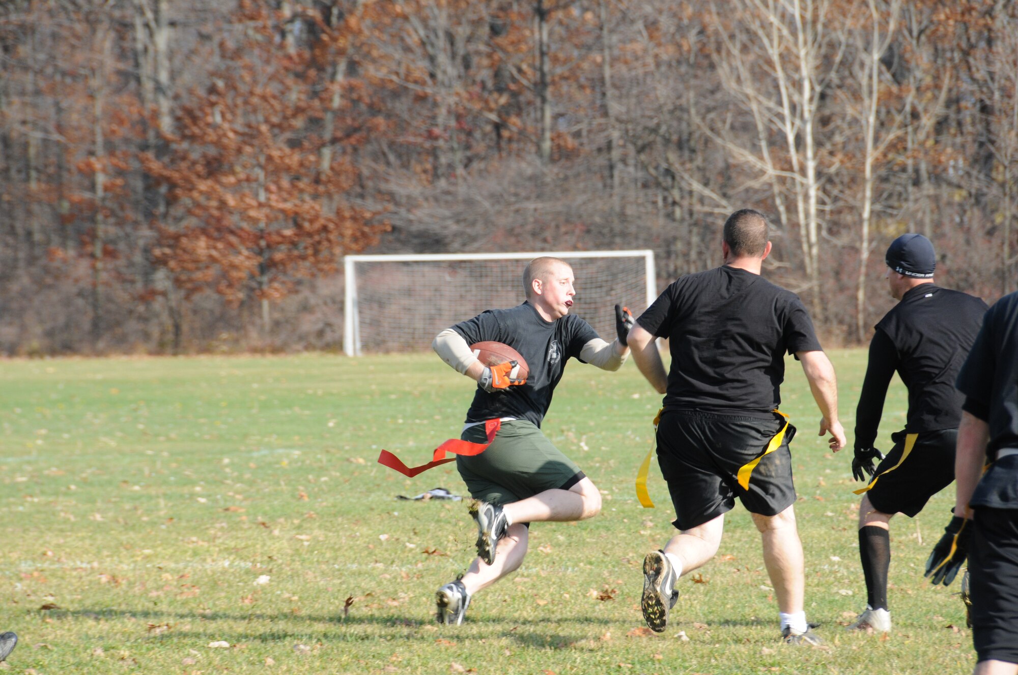 Senior Airman Nathanael Flateau, 107th Airlift Wing Security Forces Squadron, out maneuvers his opponents for a positive gain. His opponents, the U.S. Coast Guard, Cleveland Station, Ohio, and other members of local military, Homeland Security and law enforcement agencies spent the day playing ball for the benefit of the Toys for Tots program. U.S. Air Force photo/Senior Airman Peter Dean

 