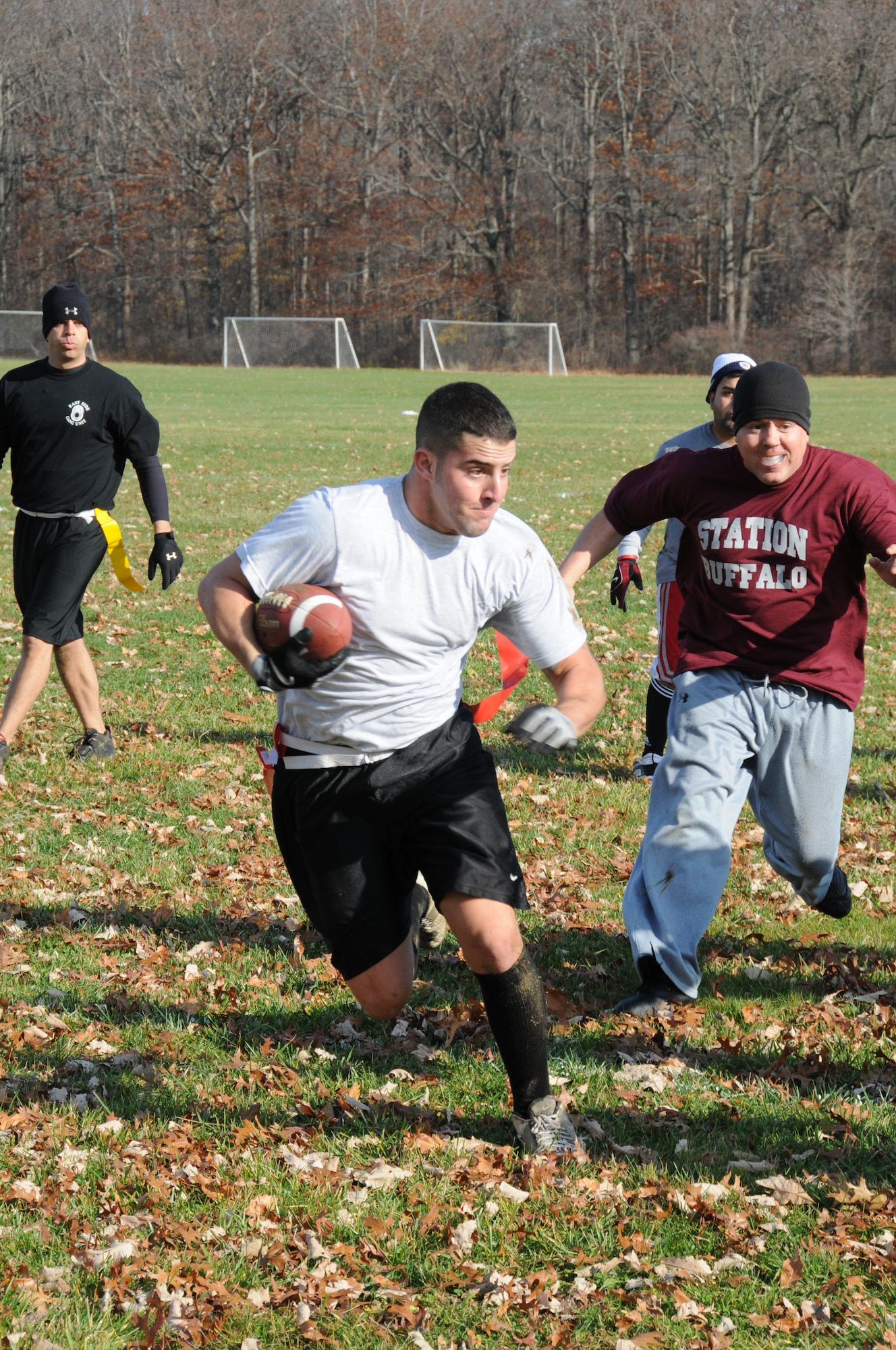 Senior Airman Michael Badolato, 107th Airlift Wing Security Force Squadron charges ahead for positive yardage. The Airman along with other military, Homeland Security and law enforcement agencies were invited to participate in a day full of flag football to benefit the Toys for Tots program. U.S. Air Force photo/Senior Airman Peter Dean