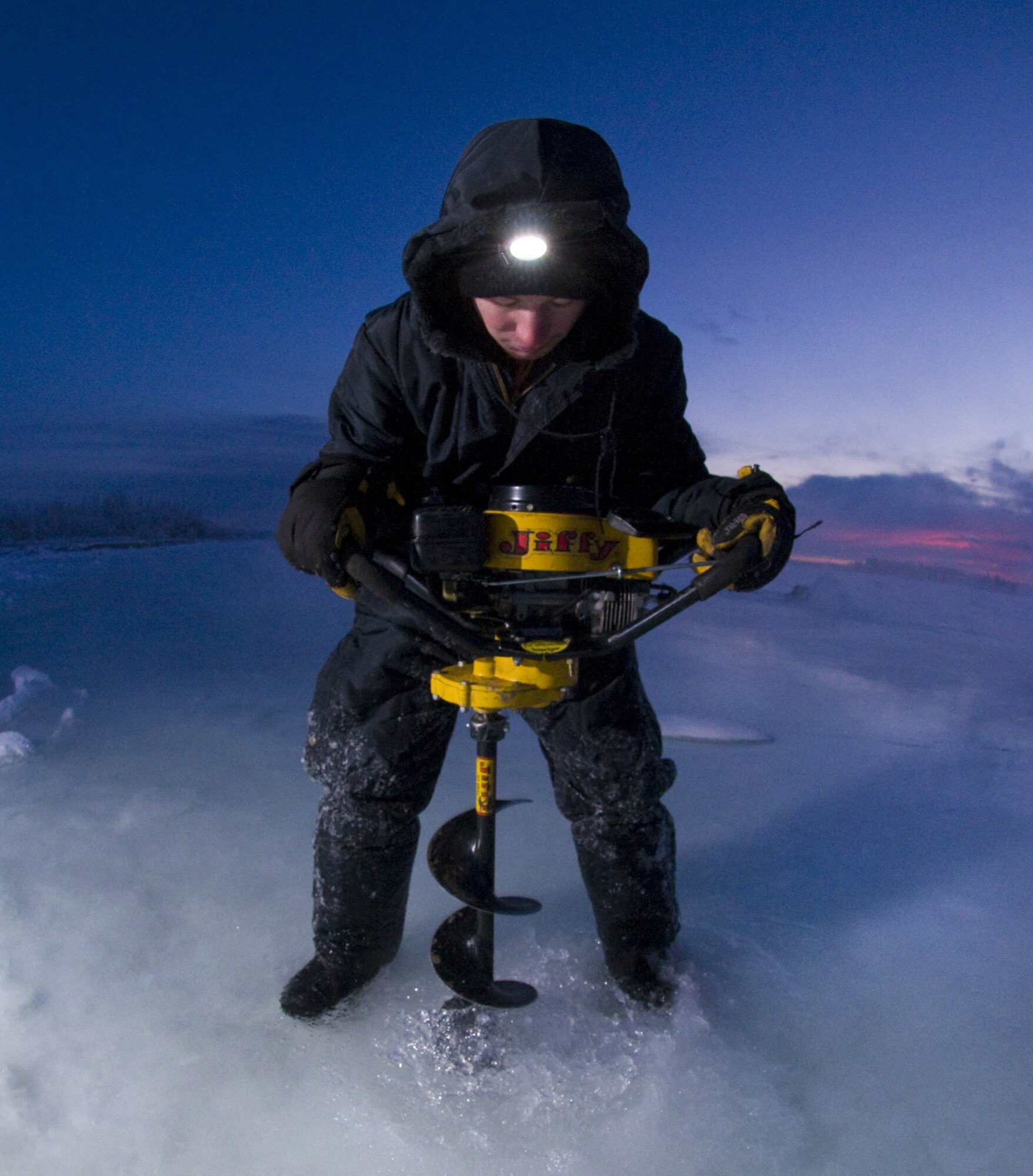 Airman 1st Class Caleb Hurley uses an ice auger on the Tanana River Nov. 24, 2008, Fairbanks, Alaska in the first phase to building an ice bridge. Airman Hurley is with the 354th Civil Engineer Squadron. The ice bridge provides the 354th CES members access to perform annual maintenance on Eielson's training and bombing ranges. The process of building the ice bridge takes six to 10 weeks in a sub-arctic enviroment and will later melt back into the river in the summer months. (U.S. Air Force photo/Airman Laura Max)(released) 
