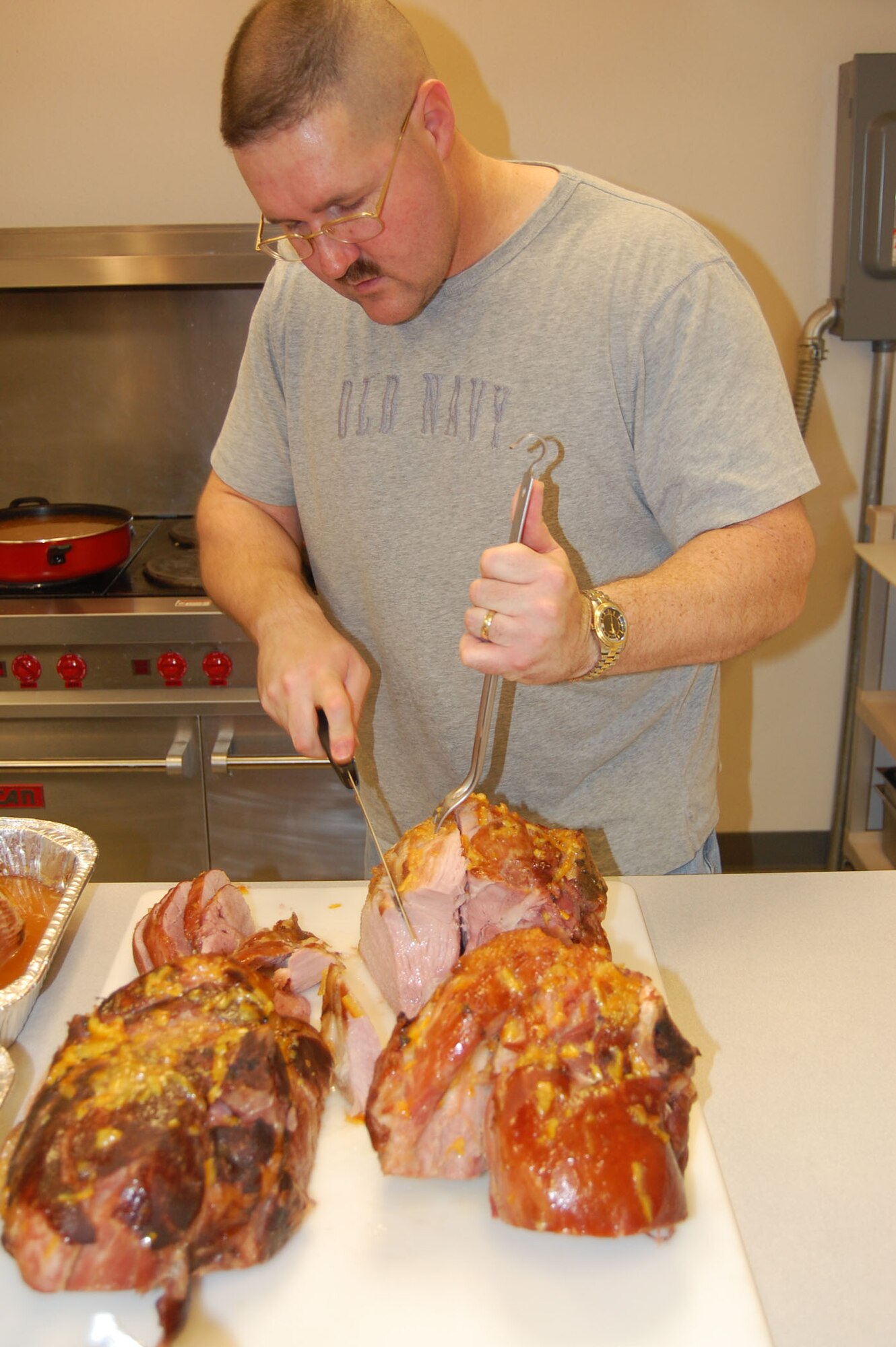Master Sgt. Jimmy Jackson, 341st Missile Maintenance Squadron first sergeant, gets busy carving the 90-pounds of ham his wife, Trina, prepared for the chapel's annual community dinner. The event was held Nov. 23 at the chapel annex. (U.S. Air Force photo/Valerie Mullett)