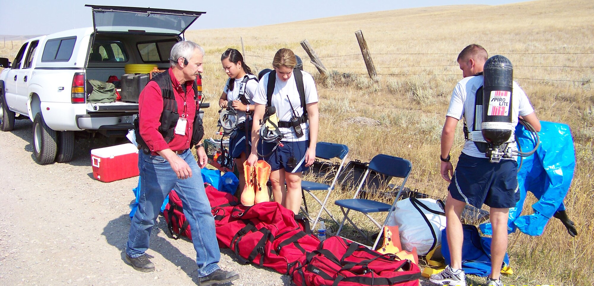 Royce Shipley, senior emergency manager for Malmstrom, double checks the equipment of CERF members before they put it on. The group was participating in an emergency reponse exercise in Sweetgrass, Mont., earlier this year. Left to right are Senior Airman Marigold Devillo, 341st Medical Operations Squadron bioenvironmental engineering flight; and Airmen 1st Class Rebecca Chase and Terren Yost, 341st Civil Engineer Squadron emergency management technicians. (U.S. Air Force courtesy photo)