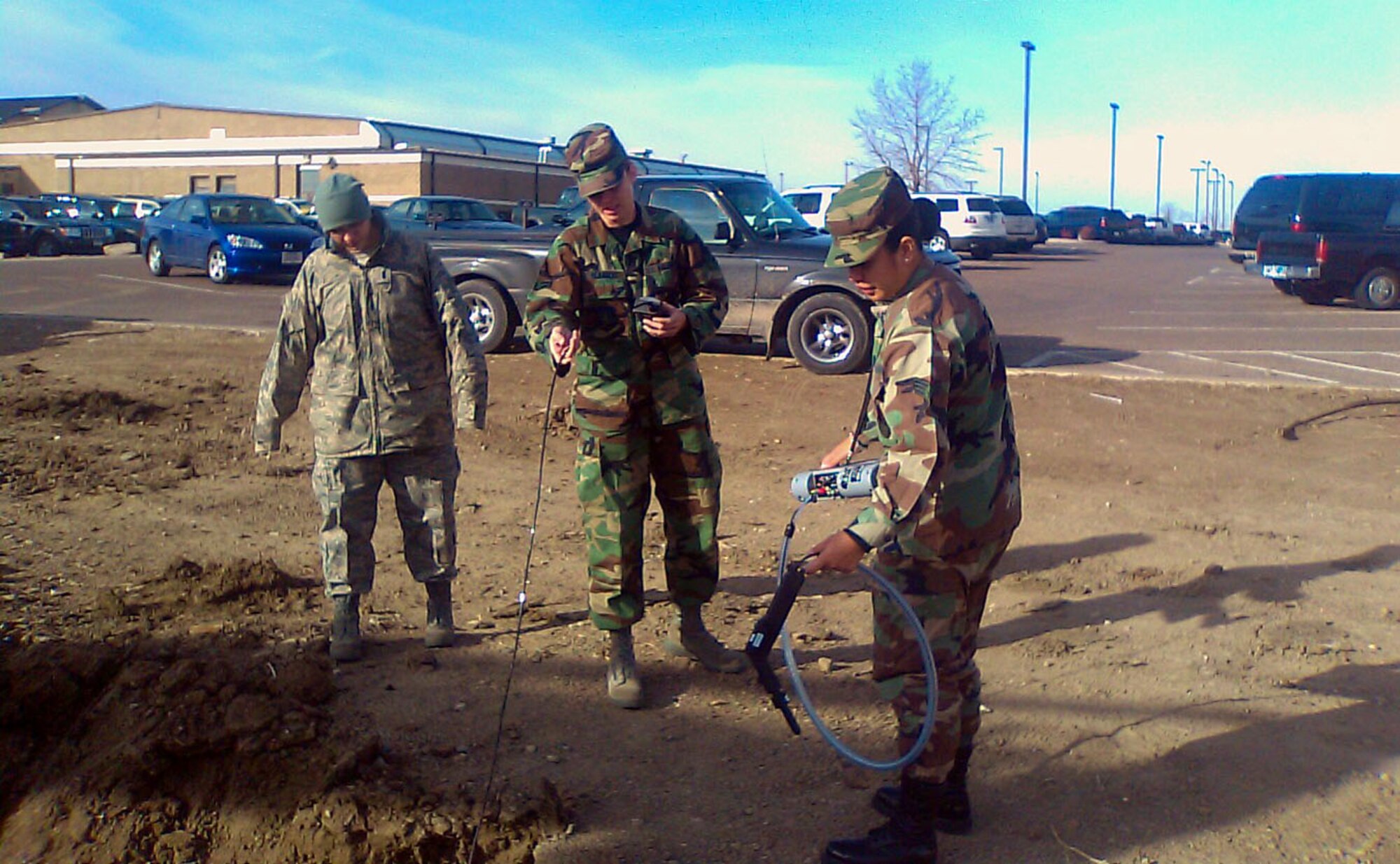 1Lt. Crystal Brown watches as her co-workers in the bioenvironmental engineering shop, Airman 1st Class Margie Blansett and Senior Airman Marigold Devillo test the hydrocarbon levels at a digging site near budiling 500. The two found the levels to be at a safe amount. (U.S. Air Force photo/Tech. Sgt. Ignacio Florendo)