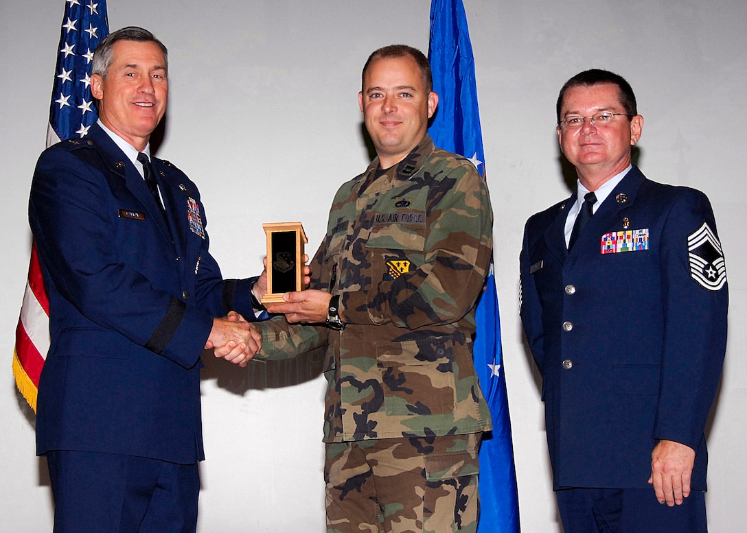 Capt. Brandon Farinelli, center, of the 372nd Training Squadron accepts the Flight Chief of the Quarter award on behalf of Senior Master Sgt. Scott Miller of the 982nd Training Group Nov. 20 from 82nd Training Wing Commander Brig. Gen. O.G. Mannon during the Quarterly Tech Training Awards at the base theater. Also pictured is Chief Master Sgt. Michael Crowley, 882nd TRG superintendent. (U.S. Air Force photo/Harry Tonemah)