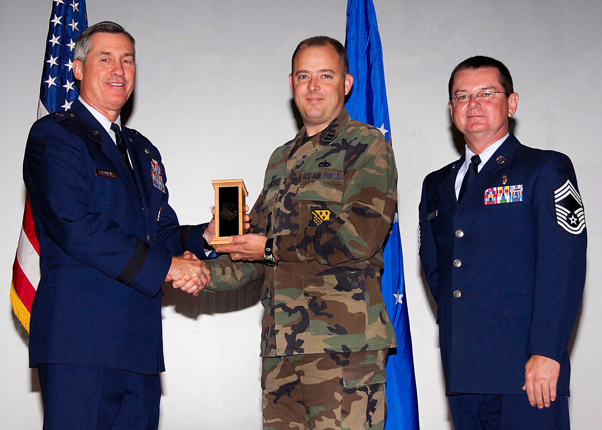 Capt. Brandon Farinelli, center, of the 372nd Training Squadron accepts the Flight Chief of the Quarter award on behalf of Senior Master Sgt. Scott Miller of the 982nd Training Group Nov. 20 from 82nd Training Wing Commander Brig. Gen. O.G. Mannon during the Quarterly Tech Training Awards at the base theater. Also pictured is Chief Master Sgt. Michael Crowley, 882nd TRG superintendent. (U.S. Air Force photo/Harry Tonemah)