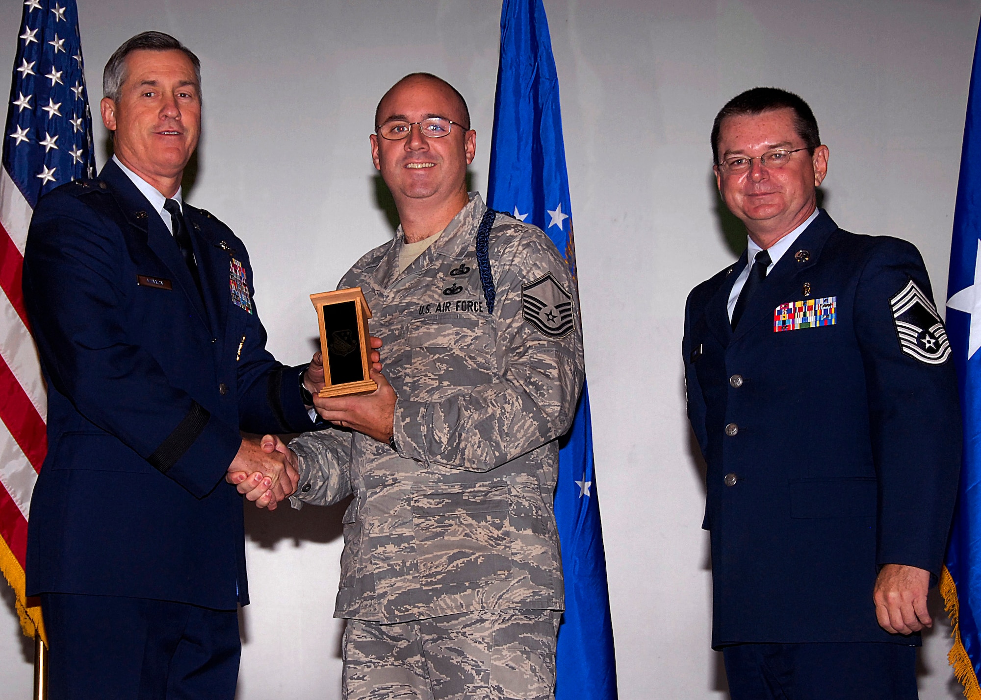 Master Sgt. Robert Smith, center, accepts the Senior Military Training Leader of the Quarter award on behalf of Master Sgt. Robert Fraley Nov. 20 from 82nd Training Wing Commander Brig. Gen. O.G. Mannon during the Quarterly Tech Training Awards at the base theater. Also pictured is Chief Master Sgt. Michael Crowley, 882nd Training Group superintendent. (U.S. Air Force photo/Harry Tonemah)
