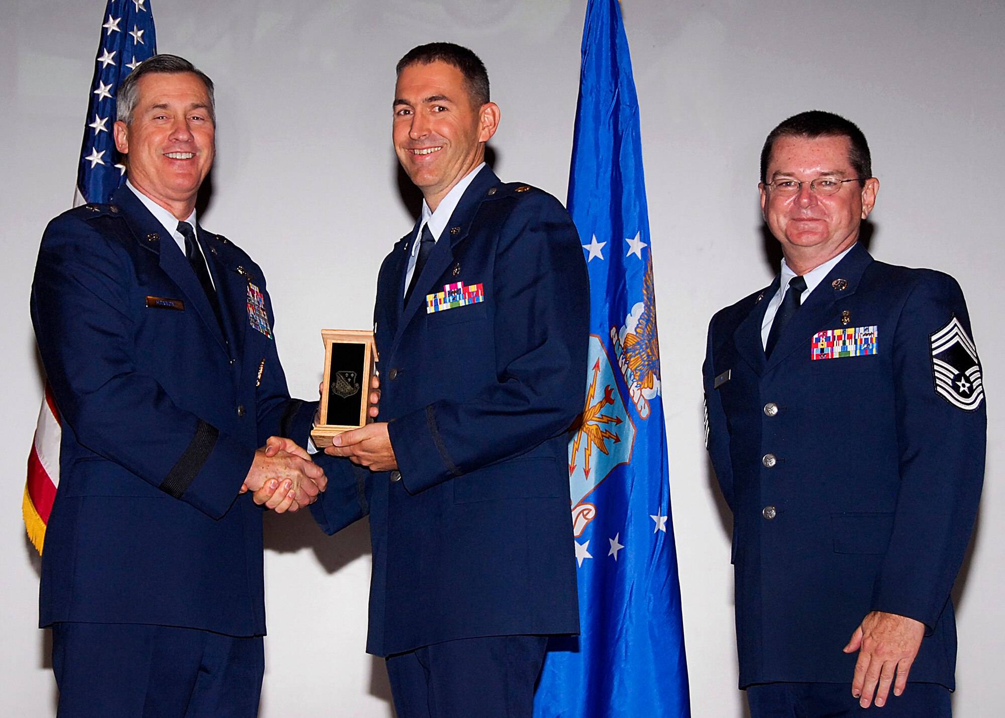 Maj. Darren Rhoton, center, of the 882nd Training Group accepts the Officer Instructor of the Quarter award from Brig. Gen. O.G. Mannon, 82nd Training Wing commander, Nov. 20 during the Quarterly Tech Training Awards in the base theater. Also pictured is Chief Master Sgt. Michael Crowley, right, superintendent of the 882nd TRG. (U.S. Air Force photo/Harry Tonemah)