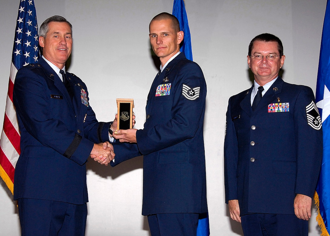Tech. Sgt. Steven McClure, center, of the 782nd Training Group accepts the NCO Instructor of the Quarter award from Brig. Gen. O.G. Mannon, 82nd Training Wing commander, Nov. 20 during the Quarterly Tech Training Awards in the base theater. Also pictured is Chief Master Sgt. Michael Crowley, right, superintendent of the 882nd TRG. (U.S. Air Force photo/Harry Tonemah)