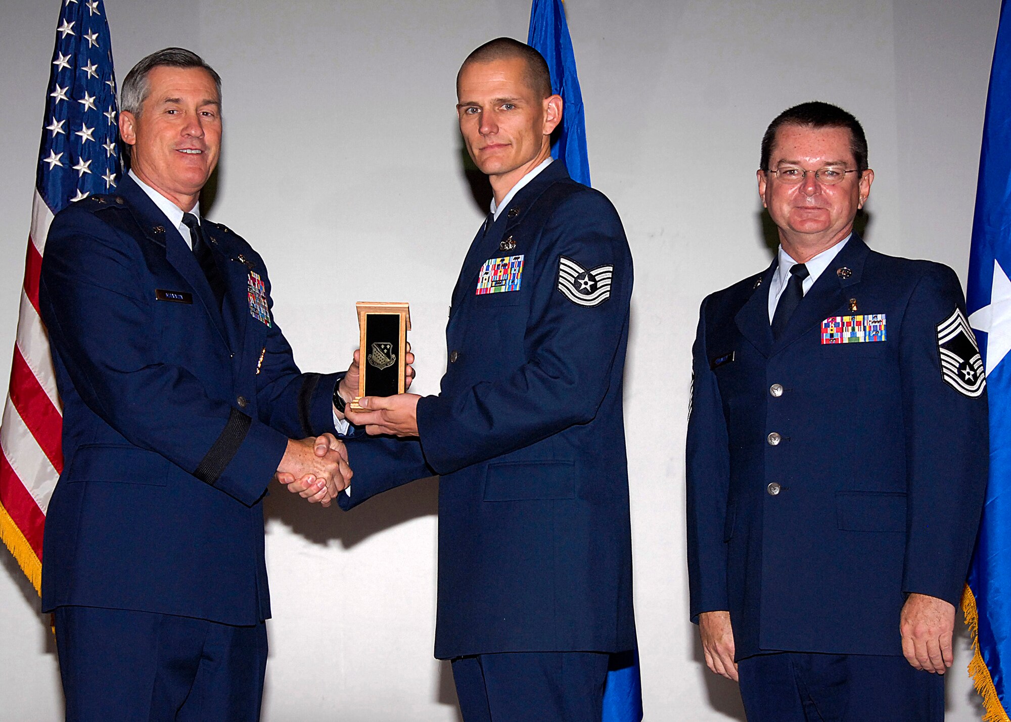 Tech. Sgt. Steven McClure, center, of the 782nd Training Group accepts the NCO Instructor of the Quarter award from Brig. Gen. O.G. Mannon, 82nd Training Wing commander, Nov. 20 during the Quarterly Tech Training Awards in the base theater. Also pictured is Chief Master Sgt. Michael Crowley, right, superintendent of the 882nd TRG. (U.S. Air Force photo/Harry Tonemah)