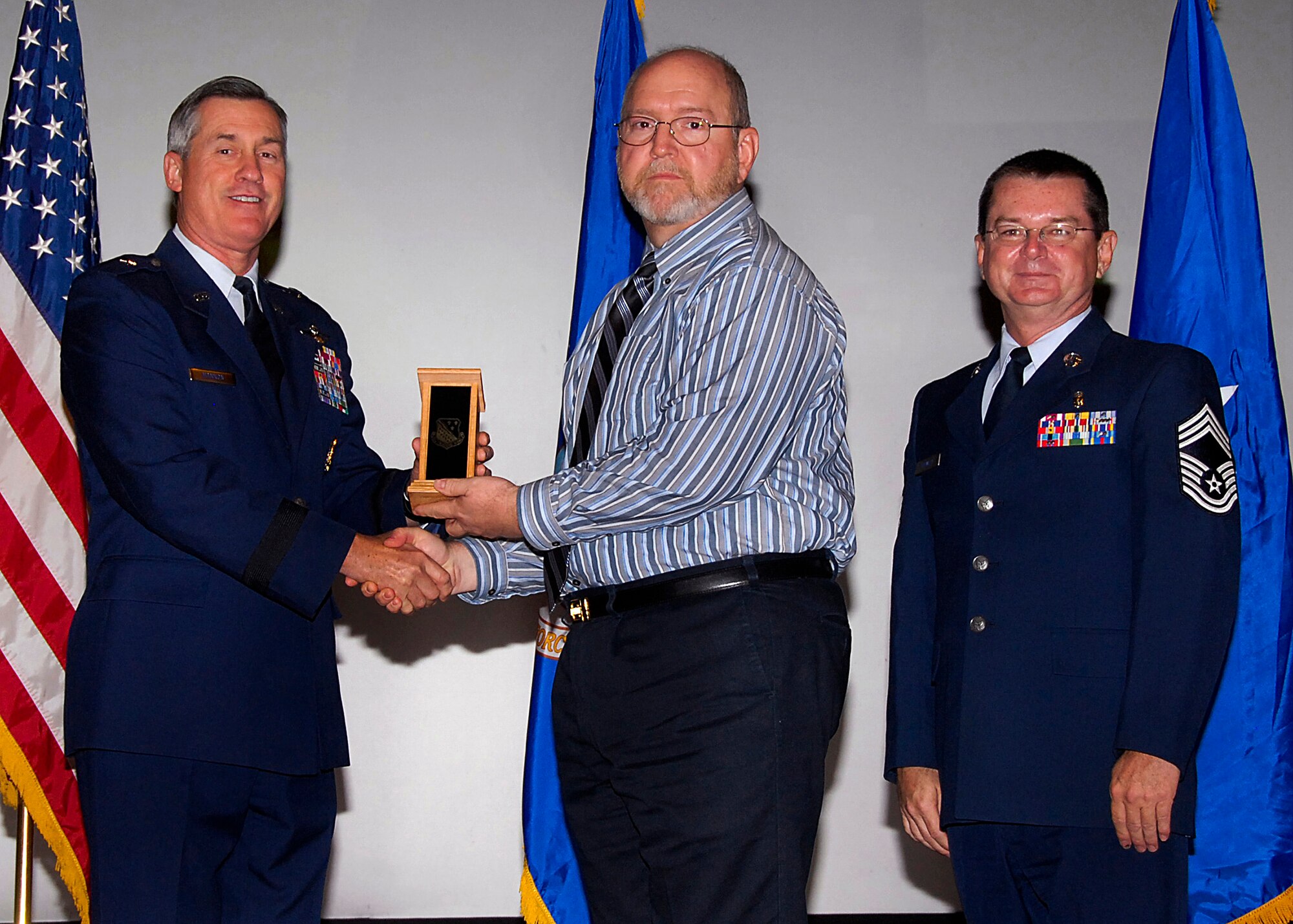Terry Kelley, center, of the 82nd Training Group accepts the Civilian Instructor of the Quarter award from Brig. Gen. O.G. Mannon, 82nd Training Wing commander, Nov. 20 during the Quarterly Tech Training Awards in the base theater. Also pictured is Chief Master Sgt. Michael Crowley, right, superintendent of the 882nd TRG. (U.S. Air Force photo/Harry Tonemah)