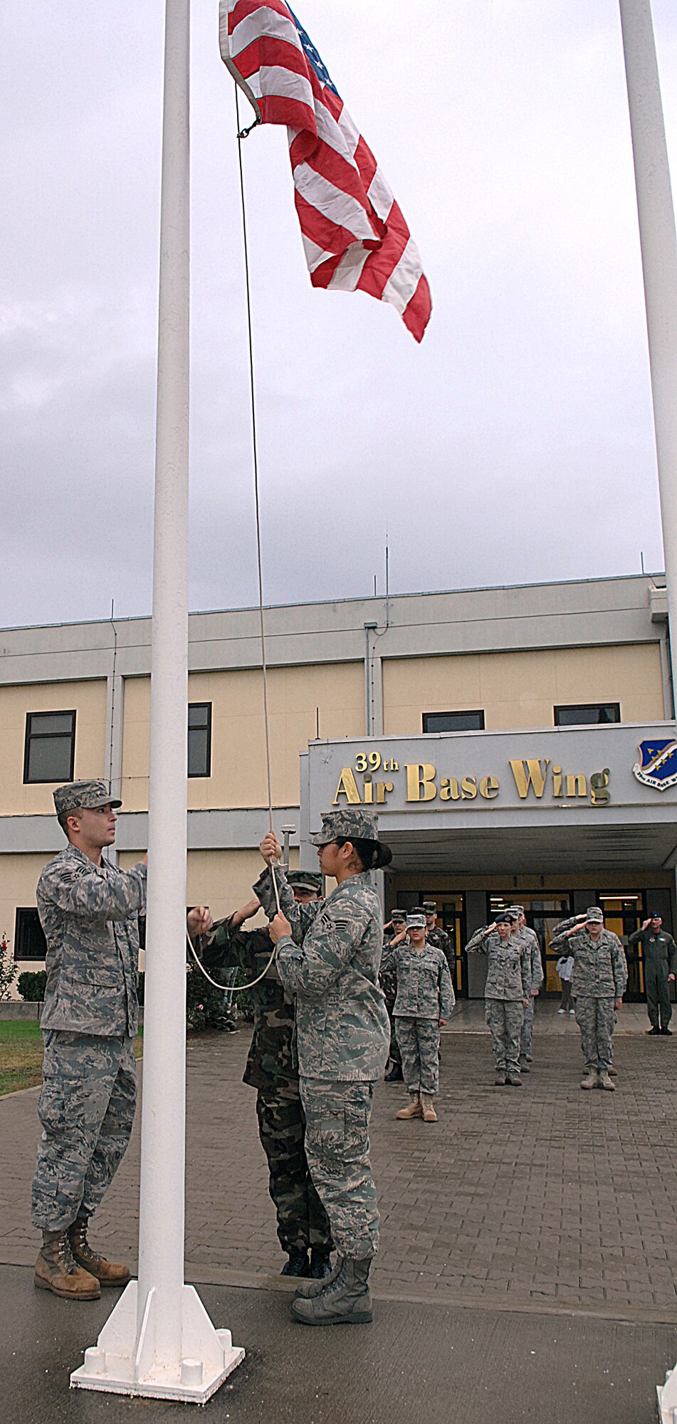 Airman Leadership School Airmen raise the flag for reveille Nov. 25. ALS prepares and trains future noncomissioned officers for their increased responsibilites. (Photo by Senior Airman Erica Stewart)