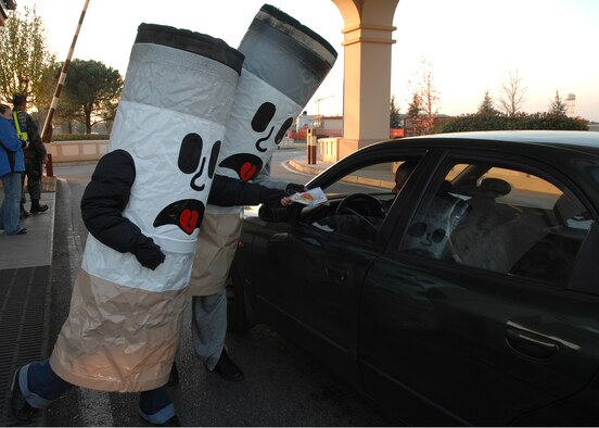 AVIANO AIR BASE, Italy -- Volunteers dressed as cigarettes at the Aviano main gate help pass out packets with tips on how to stop smoking. Hundreds of Airmen from the 31st Fighter Wing took the pledge to be tobacco-free for 24 hours during the Great American Smokeout Nov. 20. (U.S. Air Force photo/Senior Airman Taylor Marr)