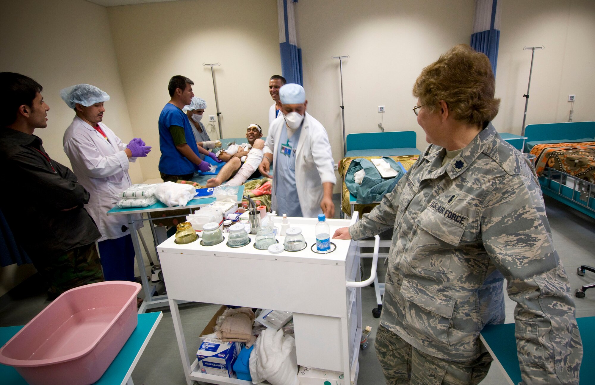 Lt. Col. Susan Bassett, a registered nurse in the 205th Afghan Regional Security Integration Command embedded training team, watches as Afghan National Army nurses dress a patient?s wounds at the Kandahar Regional Military Hospital Oct. 27, 2008. Colonel Bassett, a native of Belle Fourche, S.D., is serving a one-year deployment training ANA nurses in an effort to improve Afghanistan?s healthcare. (U.S. Air Force photo by Staff Sgt. Samuel Morse/Released)