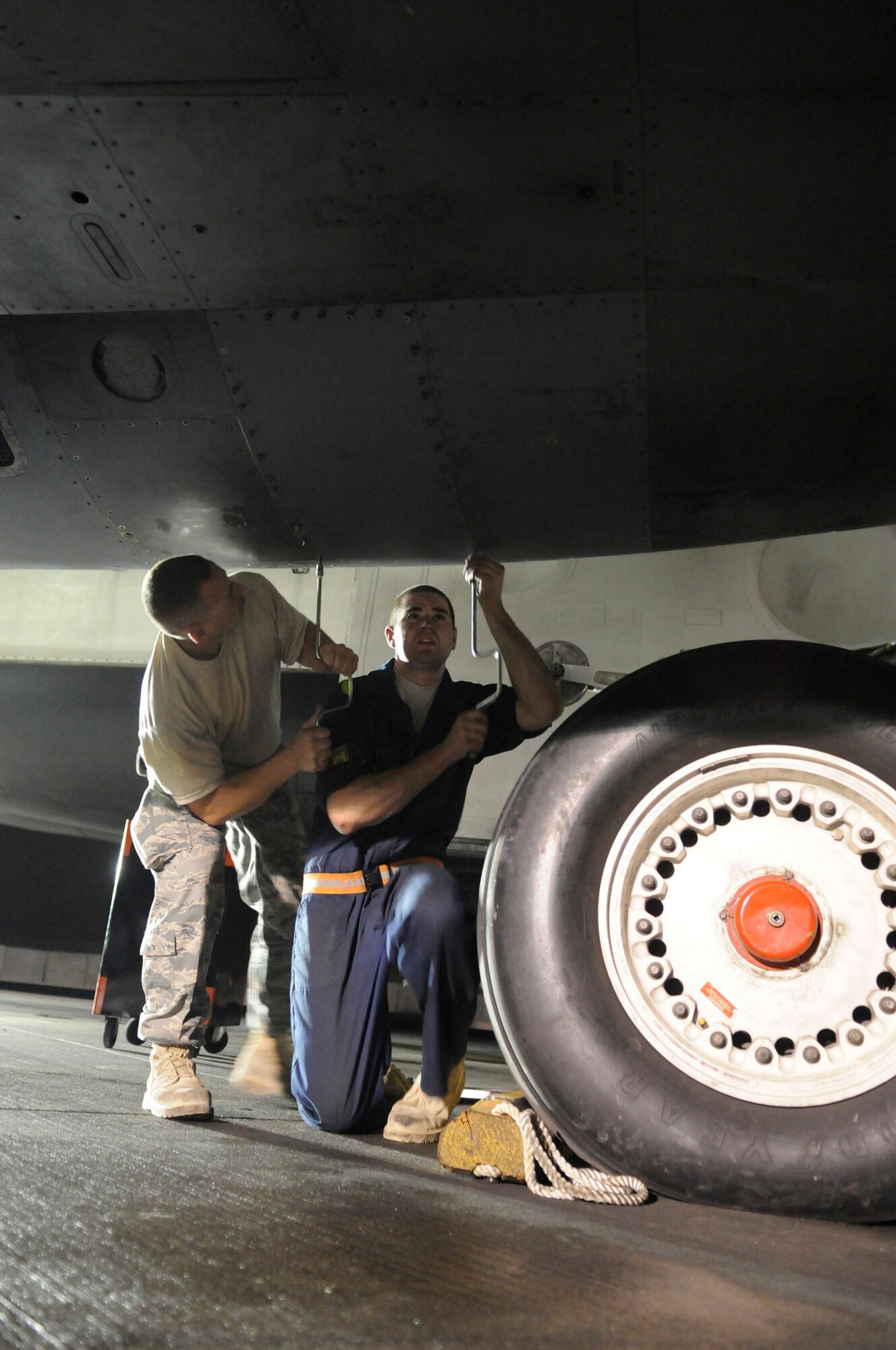 Staff Sgt. Vince Billyk and Senior Airman Reilly White, crew chiefs assigned to the 379th Expeditionary Aircraft Maintenance Squadron, tighten fasteners while replacing a gearbox panel on a B-1 Lancer, Nov. 24, at an undisclosed air base in Southwest Asia.  Carrying the largest payload of both guided and unguided weapons in the Air Force inventory, the multi-mission B-1 is the backbone of America's long-range bomber force. It can rapidly deliver massive quantities of precision and non-precision weapons against any adversary, anywhere in the Central Command area of responsibility.  Sergeant Billyk, a native of Philadelphia, Pa., and Airman White, from Laporte, Pa., are both deployed from Ellsworth Air Force Base, S.D., in support of Operations Iraqi and Enduring Freedom and Joint Task Force-Horn of Africa.  (U.S. Air Force photo by Tech. Sgt. Michael Boquette/Released)