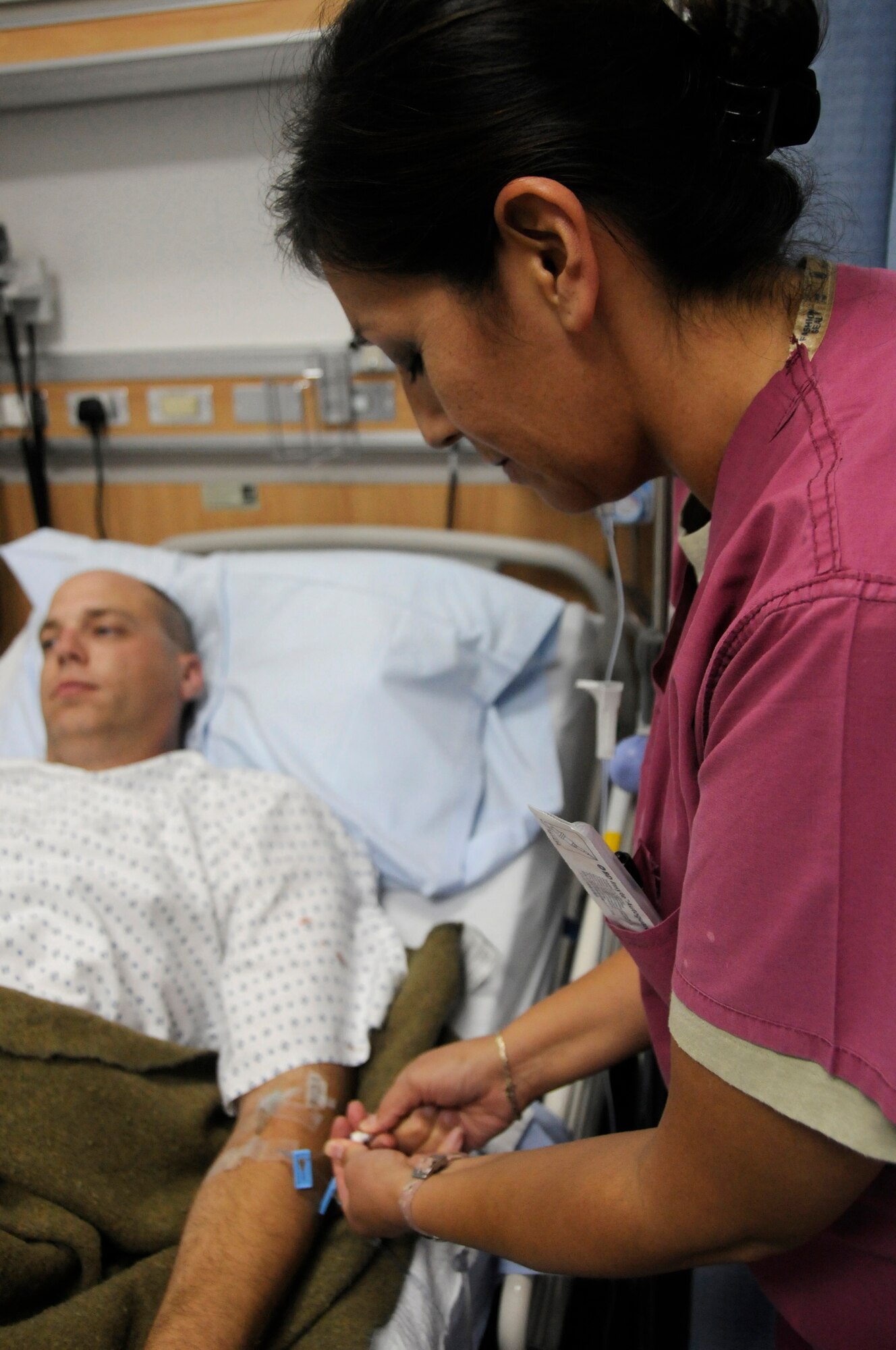 Capt. Donna LaPointe, nurse assigned to the 379th Expeditionary Medical Group, checks intravenous medication and fluid of a patient Nov. 24, at an undisclosed air base in Southwest Asia.  The 379 EMDG provides in-theater patient care for service members lightly wounded or injured in the Global War on Terror.  Captain LaPointe, a native of Santee, Neb., is deployed from Keesler Air Force Base, Miss., in support of Operations Iraqi and Enduring Freedom and Joint Task Force-Horn of Africa. (U.S. Air Force photo by Staff Sgt. Darnell T. Cannady/Released)