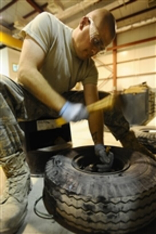 U.S. Air Force Senior Airman Cory Nimz removes a wheel bearing from the tire of a piece of aerospace ground equipment at Joint Base Balad, Iraq, prior to cleaning them on Nov. 18, 2008.  The cleaning allows the unit to move more efficiently by preventing deterioration. Nimz is an aerospace ground equipment journeyman assigned to the 332nd Expeditionary Maintenance Squadron.  
