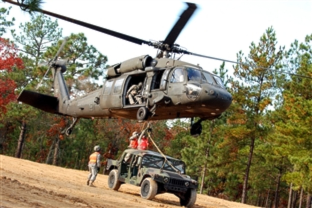 Two paratroopers attach a Humvee by harness to the bottom of a UH 60 Blackhawk helicopter during sling load training, Fort Bragg, N.C., Nov. 17, 2008. Sling load is a technique used to quickly move supplies from one area to another by helicopter. The paratroopers are assigned to 407th Brigade Support Battalion, 2nd Brigade Combat Team, 82nd Airborne Division.