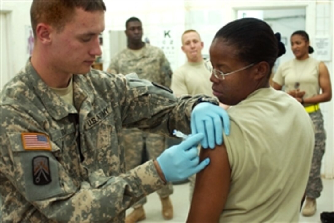U.S. Army Spc. Joshua Ryan, medic, 16th Special Troops Battalion, 16th Sustainment Brigade, administers the influenza vaccine to Staff Sgt. Jacqueline Atkins, 574th Quartermaster Company, 16th STB, at the troop medical clinic at Contingency Operating Base Q-West, Iraq, Nov. 10, 2008. 