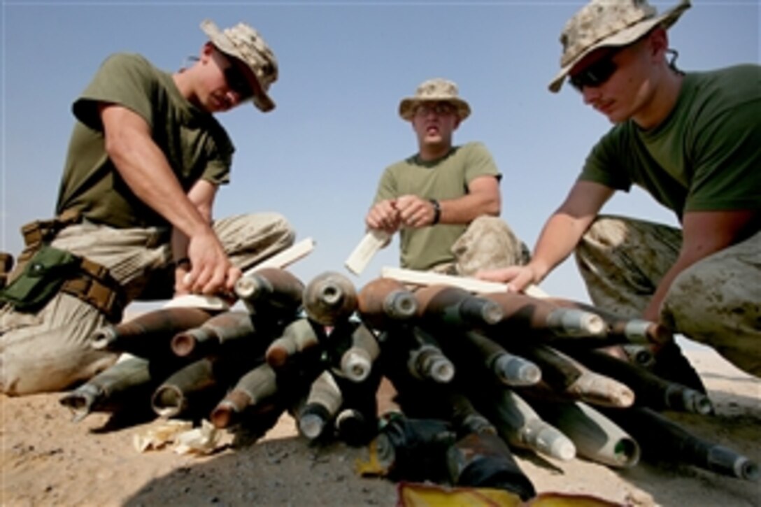Sgts. Bill Lightner, Brandon Moore and Curtis Long (from left) place C4 on a pile of unexploded ordnance in a training site in the Middle East, Nov. 18, 2008. The 26th Marine Expeditionary Unit's explosive ordnance disposal Marines safely cleared hundreds of pounds of unexploded ordnance found on a firing range, which was later to be used by the Marine Expeditionary Unit's Ground Combat Element, Battalion Landing Team 2/6, for training.