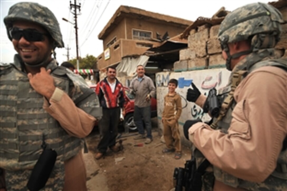 U.S. Air Force Staff Sgt. Peter Casola  and an interpreter share a laugh with Iraqi civilians during a patrol in the Doura district of Baghdad, Iraq, Nov. 22, 2008. Casola is assigned to Detachment 3, 732nd Expeditionary Security Forces Squadron, which is attached to the 4th Infantry Division's 1st Brigade Combat Team.