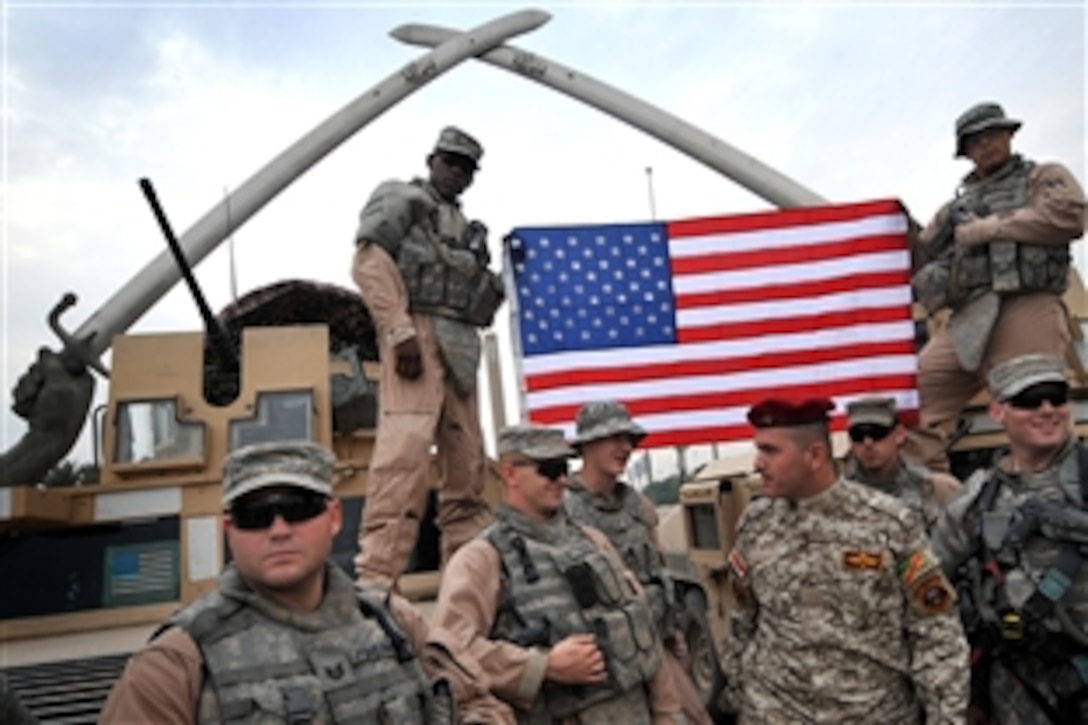 U.S. Air Force airmen and an Iraqi commando pose for a group photo in front of the Hands of Victory, also known as the Crossed Hands, in Baghdad, Iraq, Nov. 22, 2008. The monument was created 18 years ago after the Iran-Iraq War. The airmen are assigned to the 4th Infantry Division's 1st Brigade Combat Team.