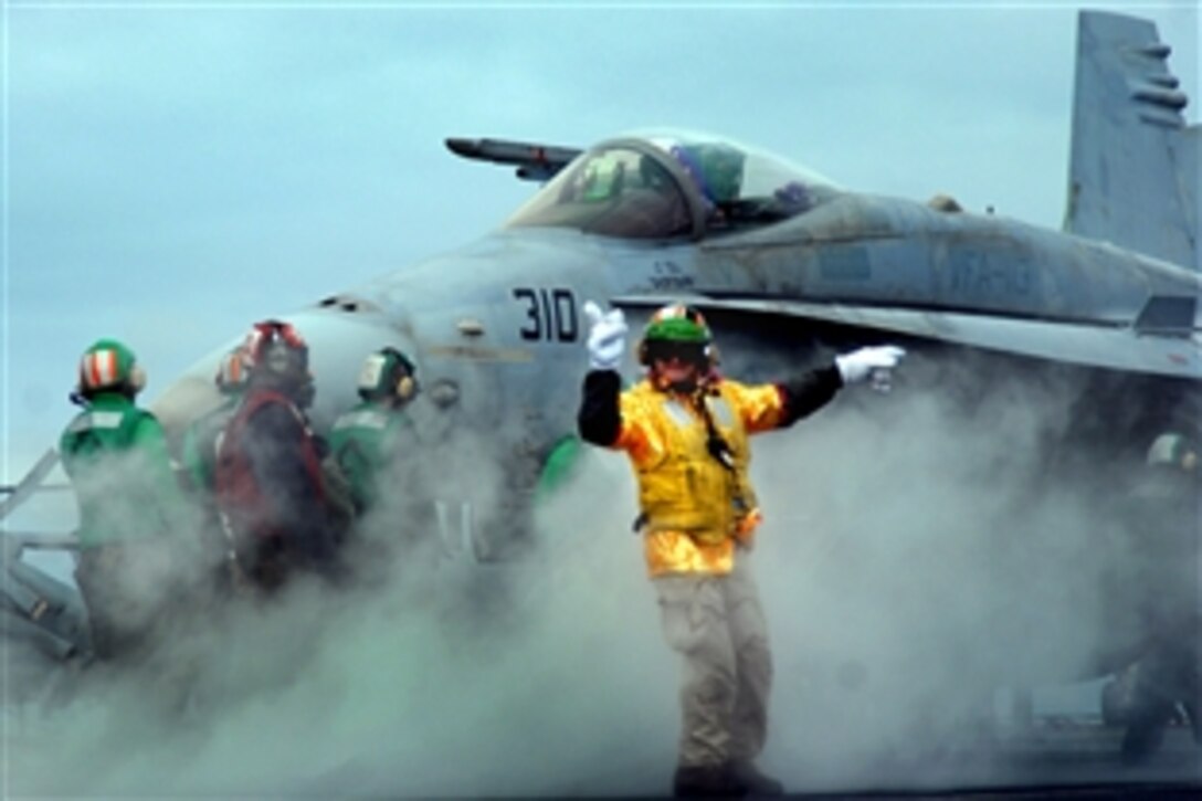Navy Lt. Cmdr. Thomas "Sputnik" Louden checks all the launch stations brfore giving the signal to launch an F/A-18C Hornet assigned to the "Stingers" of Strike Fighter Squadron during an air wing fly-off aboard the Nimitz-class aircraft carrier USS Ronald Reagan in the Pacific Ocean, Nov. 24, 2008. Ronald Reagan is on a routine deployment in the U.S. 3rd Fleet area of responsibility.