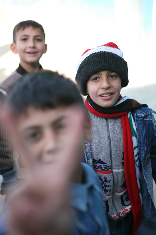 Students at an elementary school in Rawah, Iraq, - a town on the northern bank of the Euphrates River in western al Anbar province - smile at Marines from Provisional Rifle Platoon 3, Regimental Combat Team 5, who brought snacks Nov. 25 to share with the children.  The Marines brought the children treats as a gesture to show they are good neighbors.::r::::n::