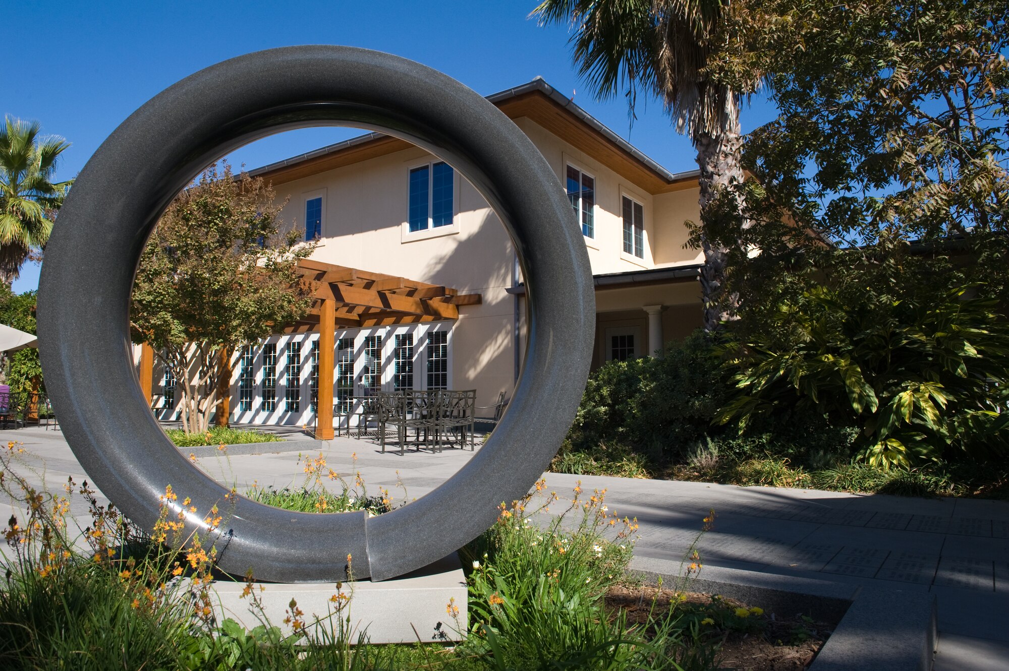 The symbol of a broken ring, cracked but still intact, sits between the two newest Fisher Houses in San Antonio, on Nov. 25.  Each of these 16,800 square foot Fisher Houses can accommodate up to 42 families visiting their injured love ones. Private donations were used to fund their construction, operation and maintenance. (U.S. Air Force photo/Lance Cheung)