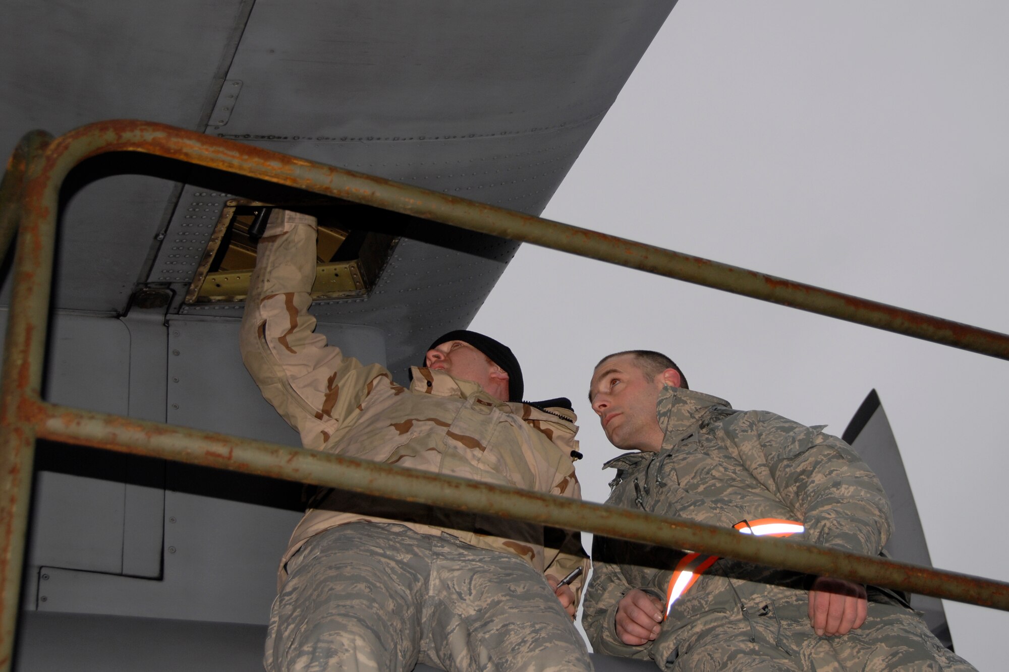 Airmen from the 133rd Airlift Wing work to install a part on a C-130 H3 in Canada. Technical Sgt. Corey Redder, 133rd Maintenance Squadron (left) helps Senior Airman Scott Mathiesen, also from the 133rd MXS, install a replacement valve on a C-130 H3 from the Minnesota Air National Guard. Redder and the crew arriving today in Canada are just returning from the combat zone, and they brought the needed part to the Minnesota C-130 crew on their way to Afghanistan.